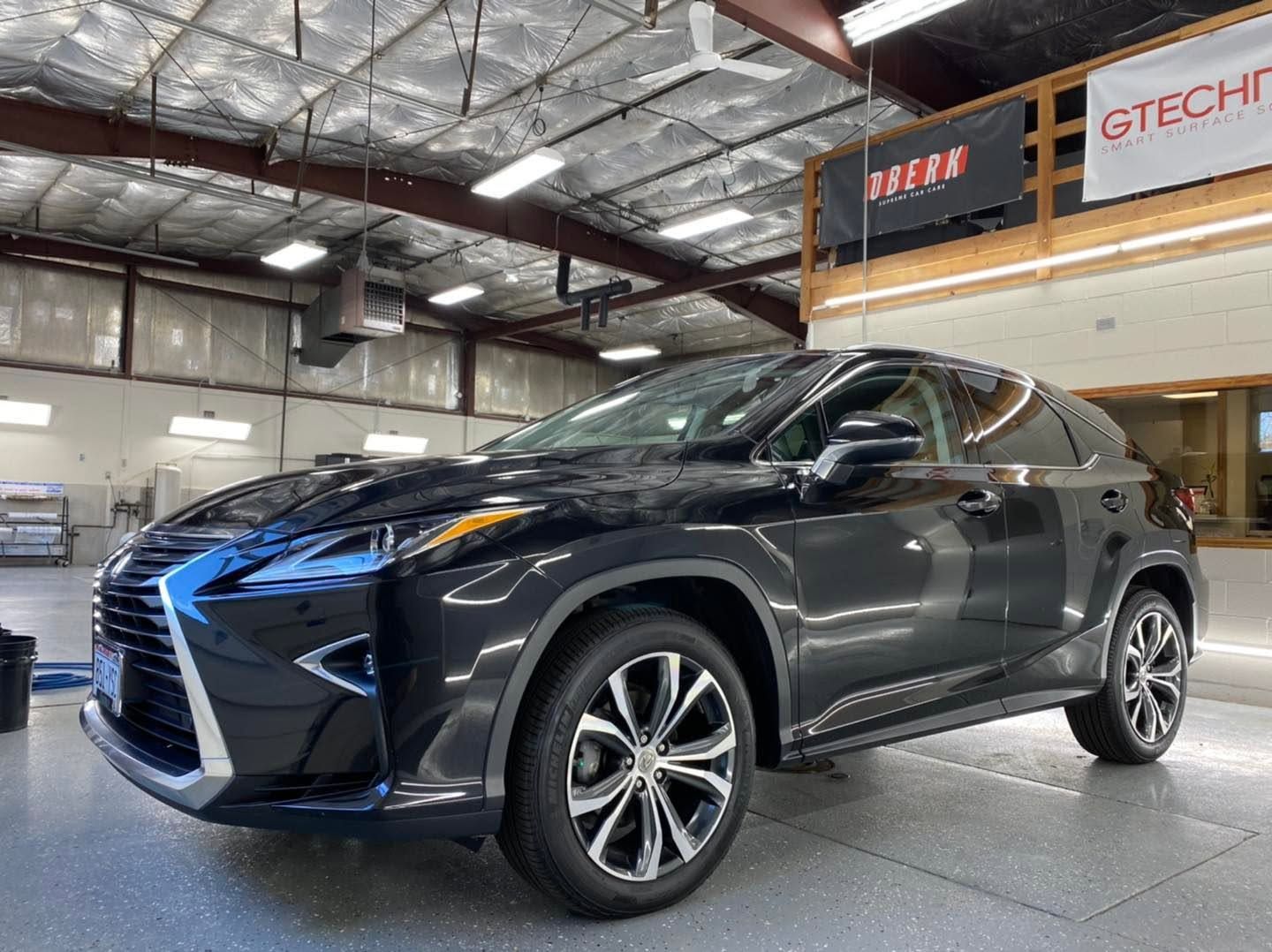 Dark gray Lexus SUV parked indoors in an auto showroom