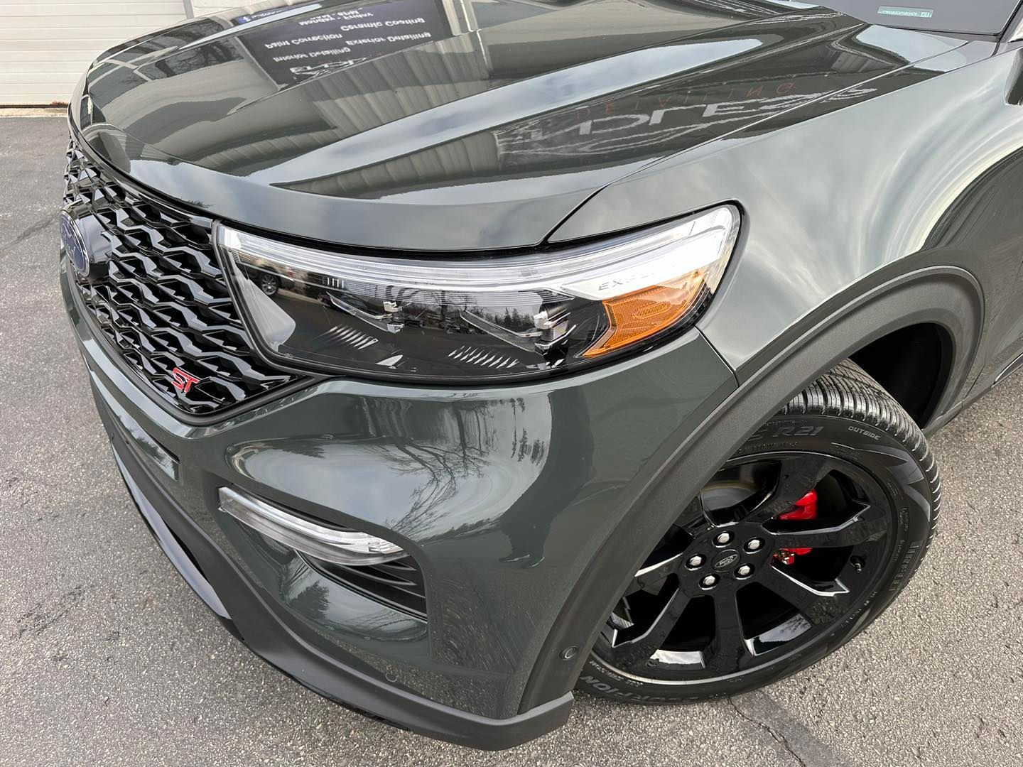 Green Ford Explorer ST, front view. Black grille, headlights, and rims with red brake calipers.