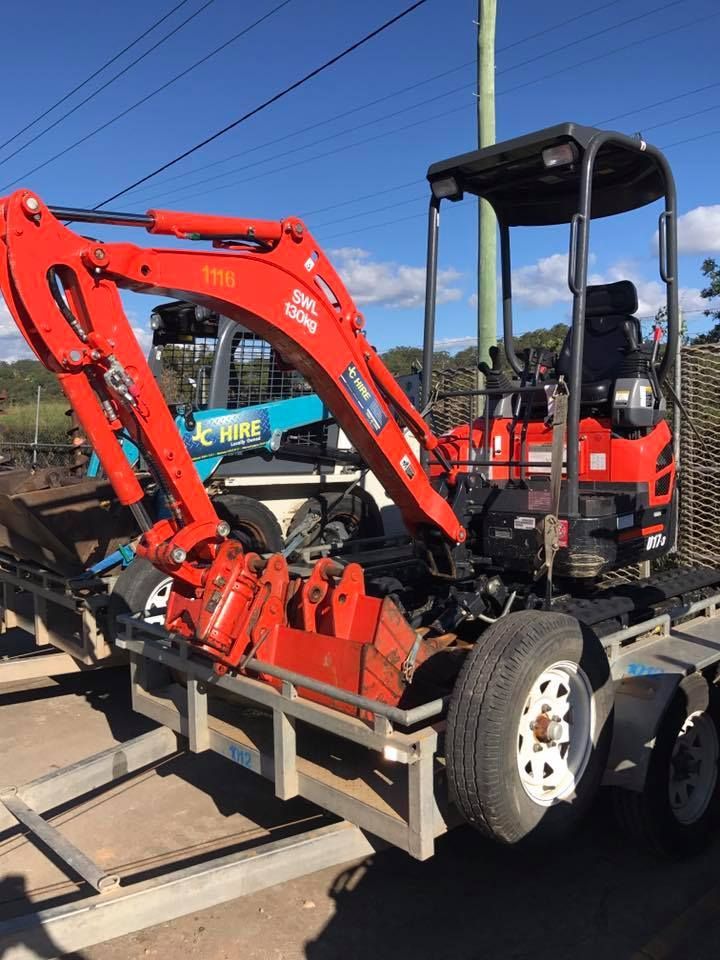 Red Mini Excavator Secured on a Flatbed Trailer Outdoors — JC Hire In Bli Bli, QLD