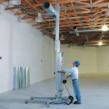 Silver material lift with extendable forks and wheels.