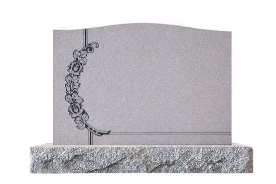 Gray tombstone with a floral vine engraving on the left side, set on a stone base.