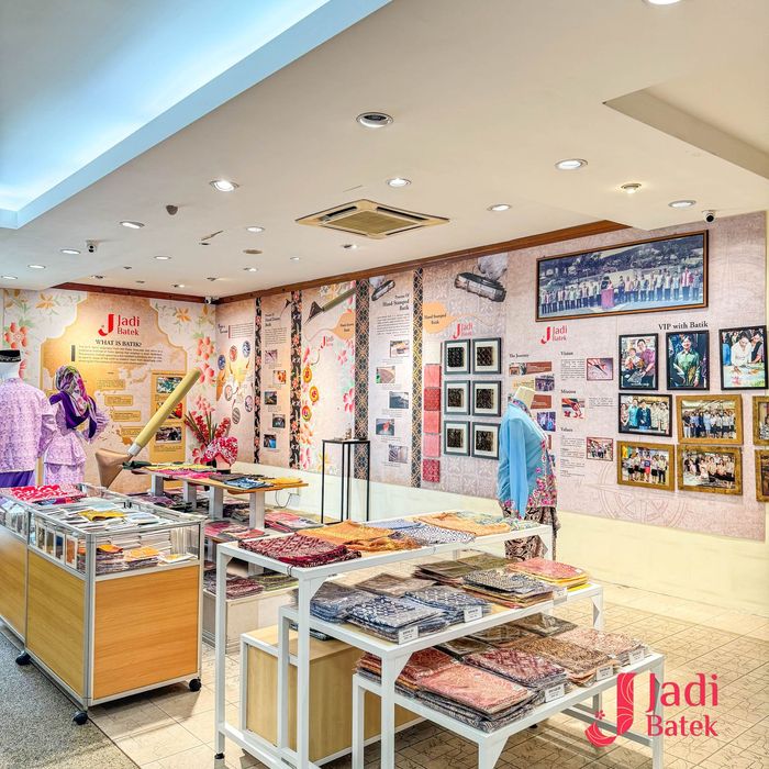 Inside a clothing store: displays of patterned fabrics and mannequins, with historical photos on the wall.