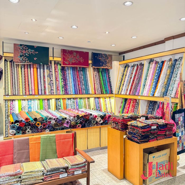 Fabric store with colorful textiles on shelves and tables.