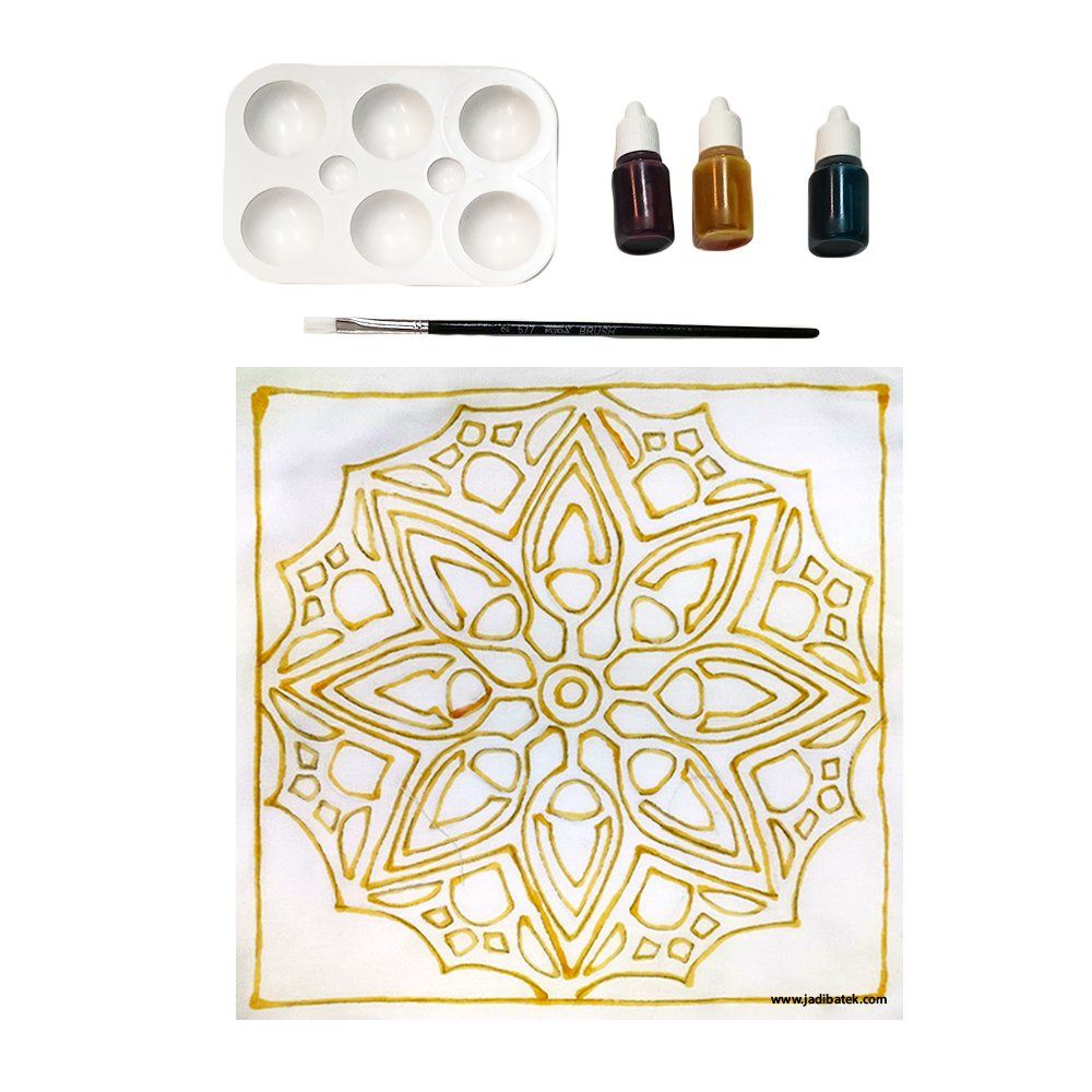 Batik art kit: white palette, three ink bottles, brush, and a fabric square with a gold outline design.