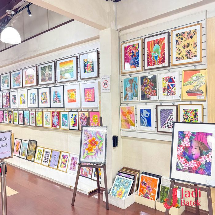 Art gallery with framed colorful paintings on display.