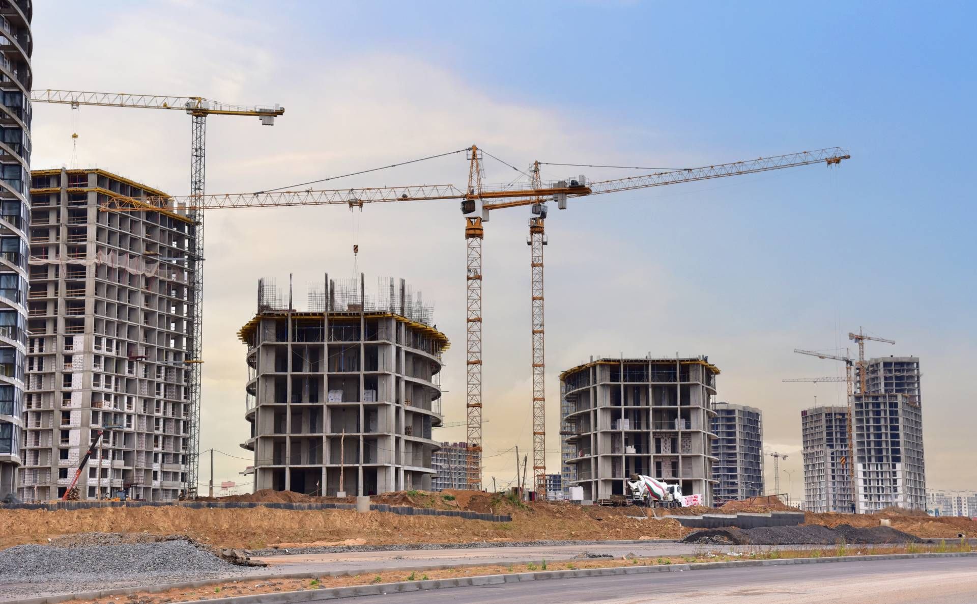 A construction site with a lot of cranes and buildings under construction.