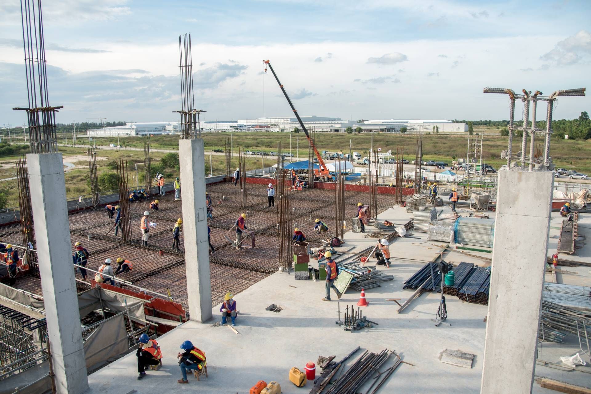 A group of construction workers are working on a large building under construction.