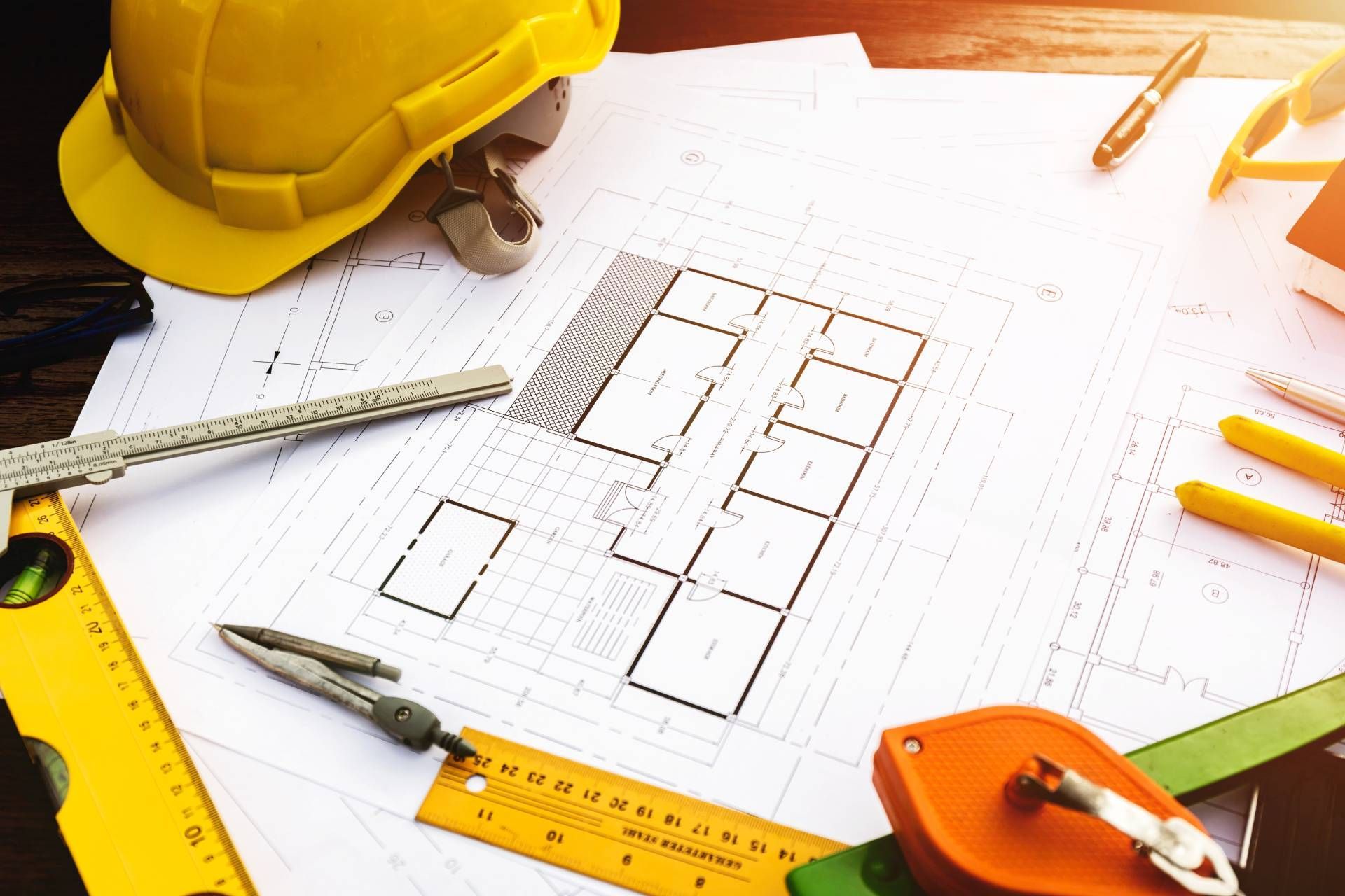 A hard hat is sitting on top of a blueprint on a table.