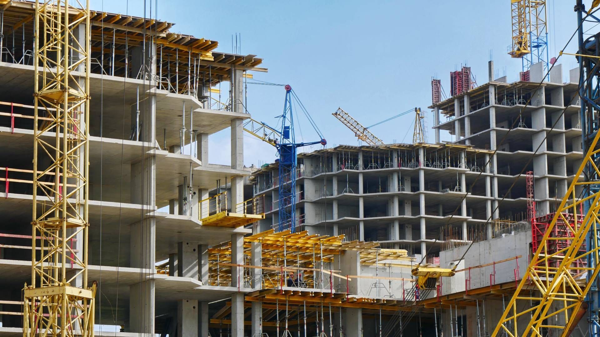 A construction site with a lot of cranes and buildings under construction.