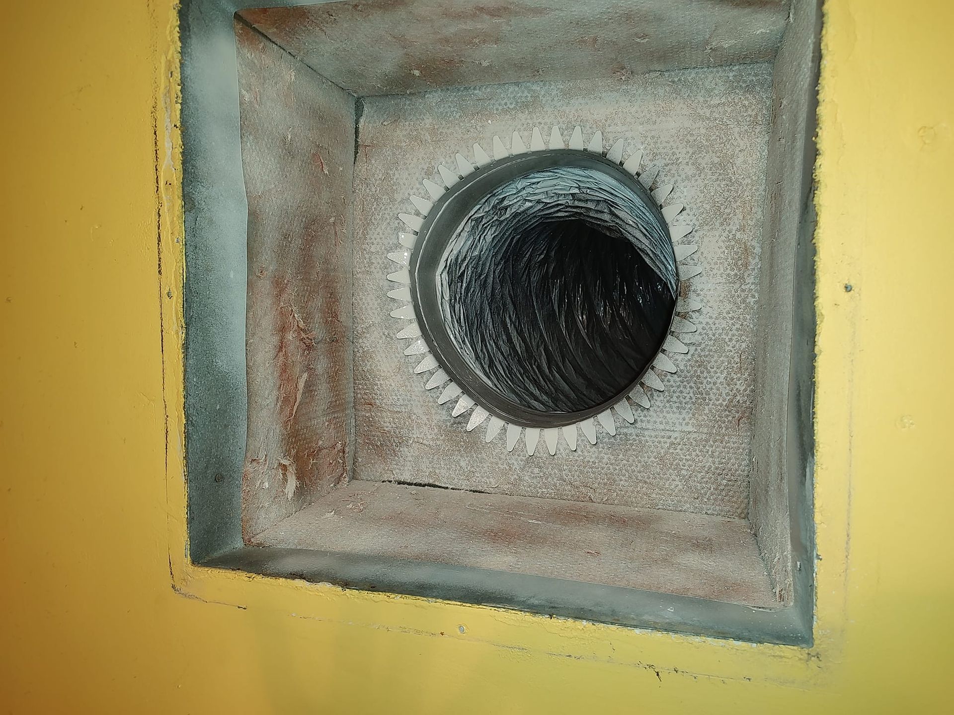 a hole in a wall with a hose coming out of it .