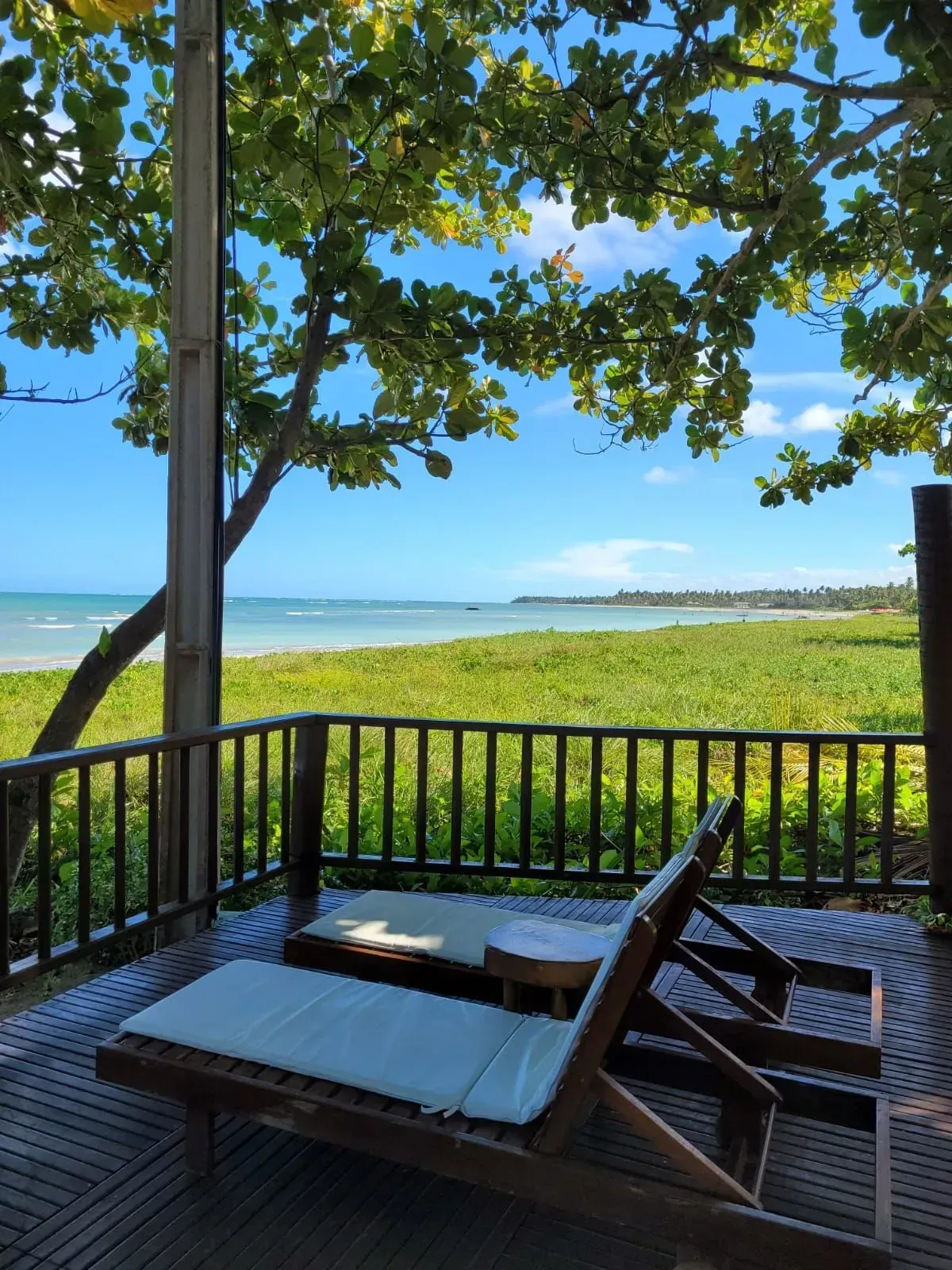 Duas espreguiçadeiras em um deck com vista para o oceano