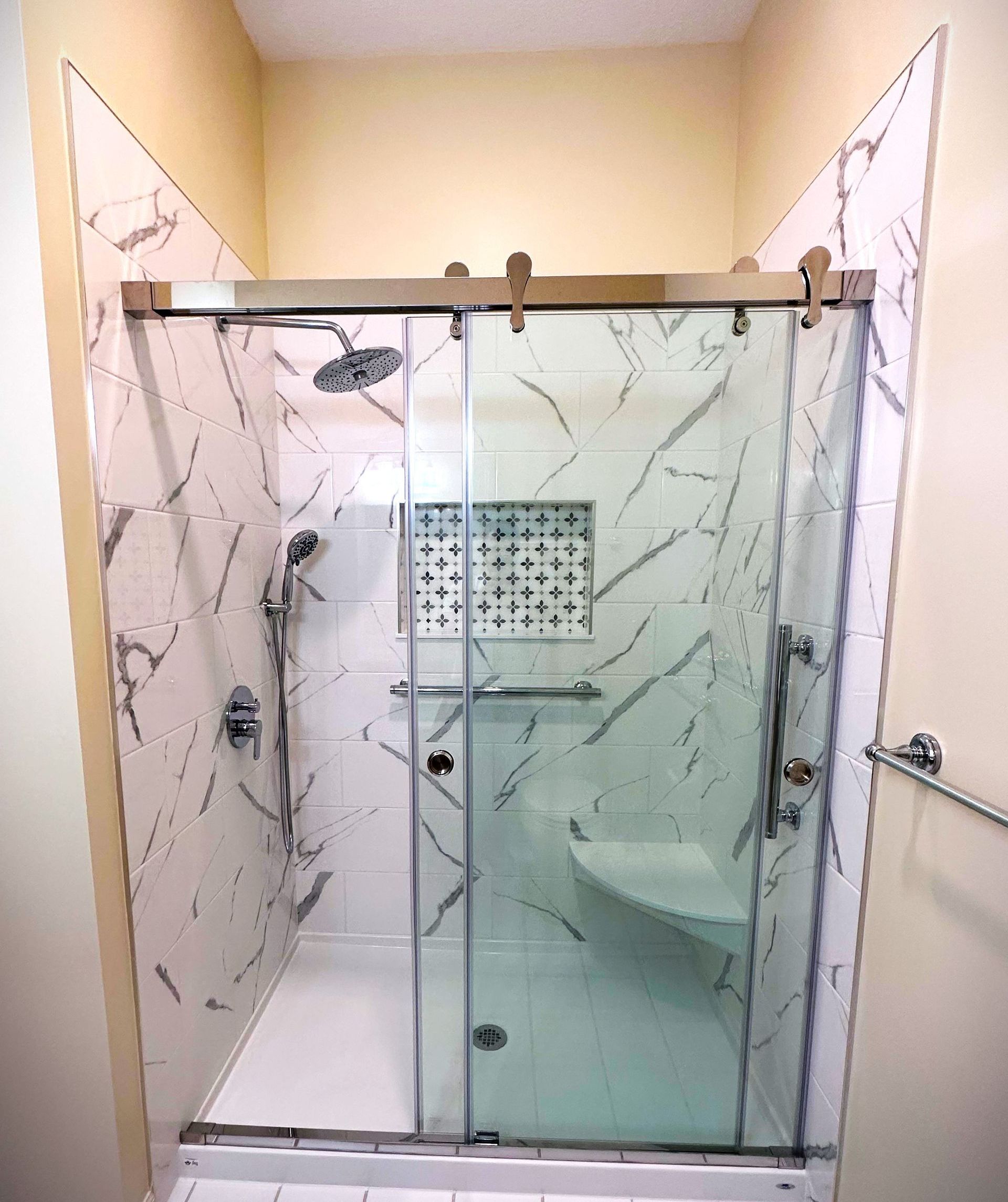 A bathroom with a sliding glass shower door and a toilet.