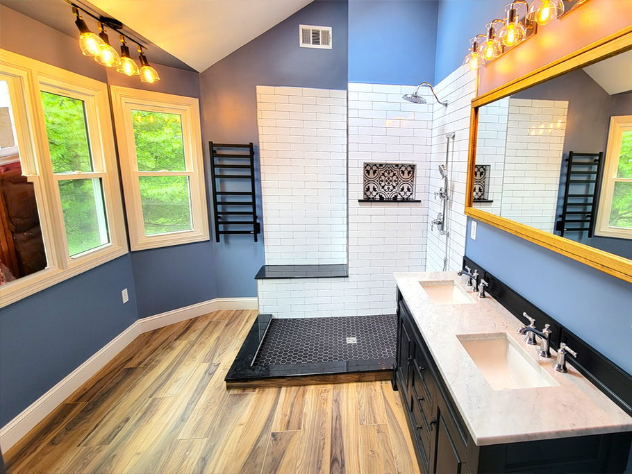 Modern bathroom remodel in Simsbury, CT with white brick shower, blue walls, wooden floors, double vanity, and windows.