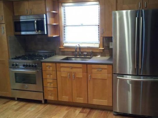 A kitchen with stainless steel appliances and wooden cabinets