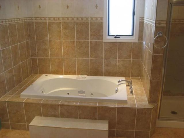 A bathtub in a bathroom next to a window
