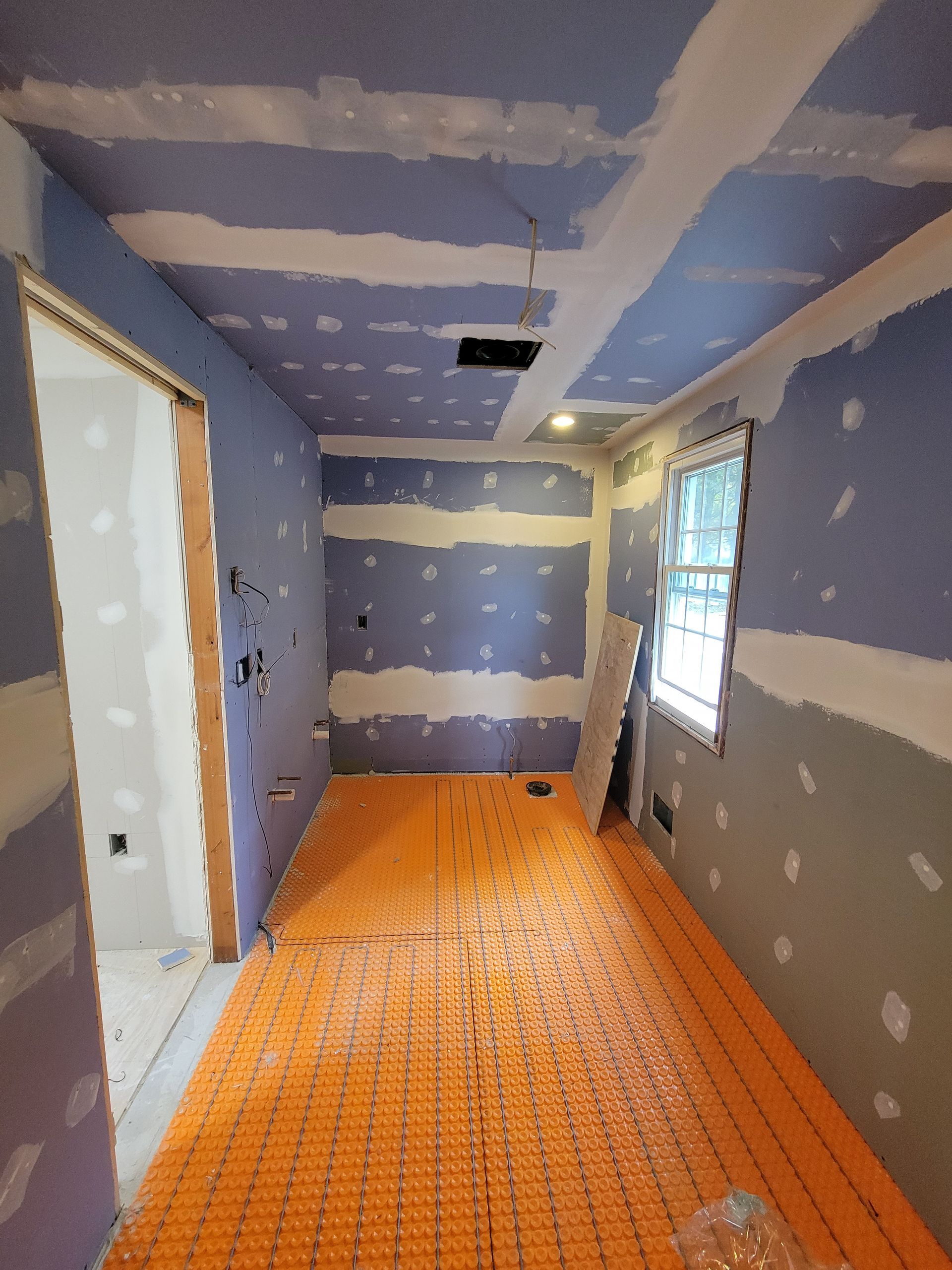 A room with a purple wall and an orange floor