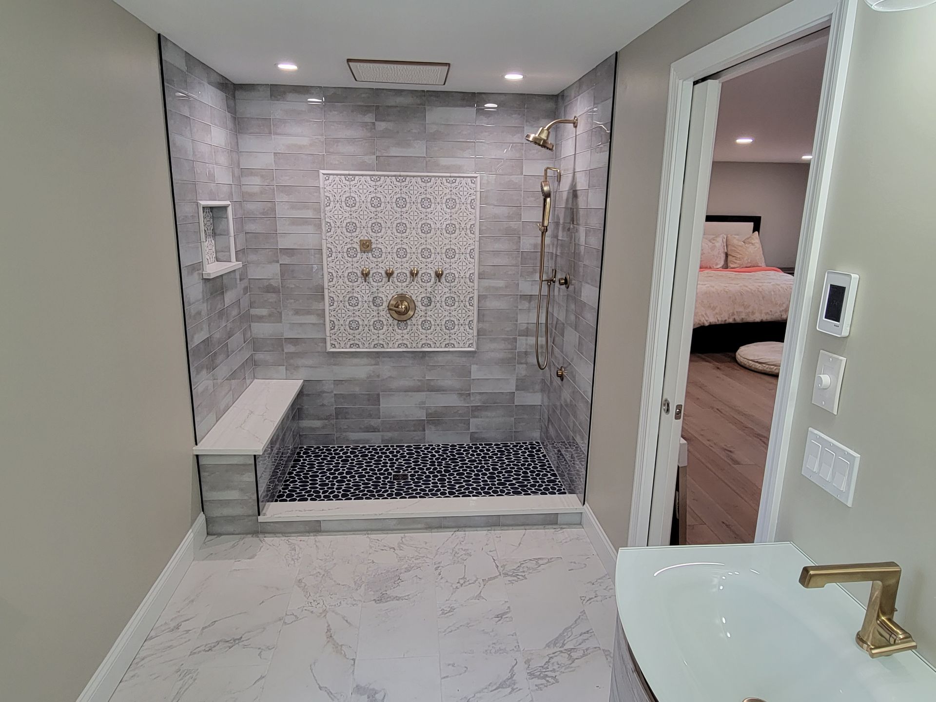 A bathroom with a walk in shower and a sink.