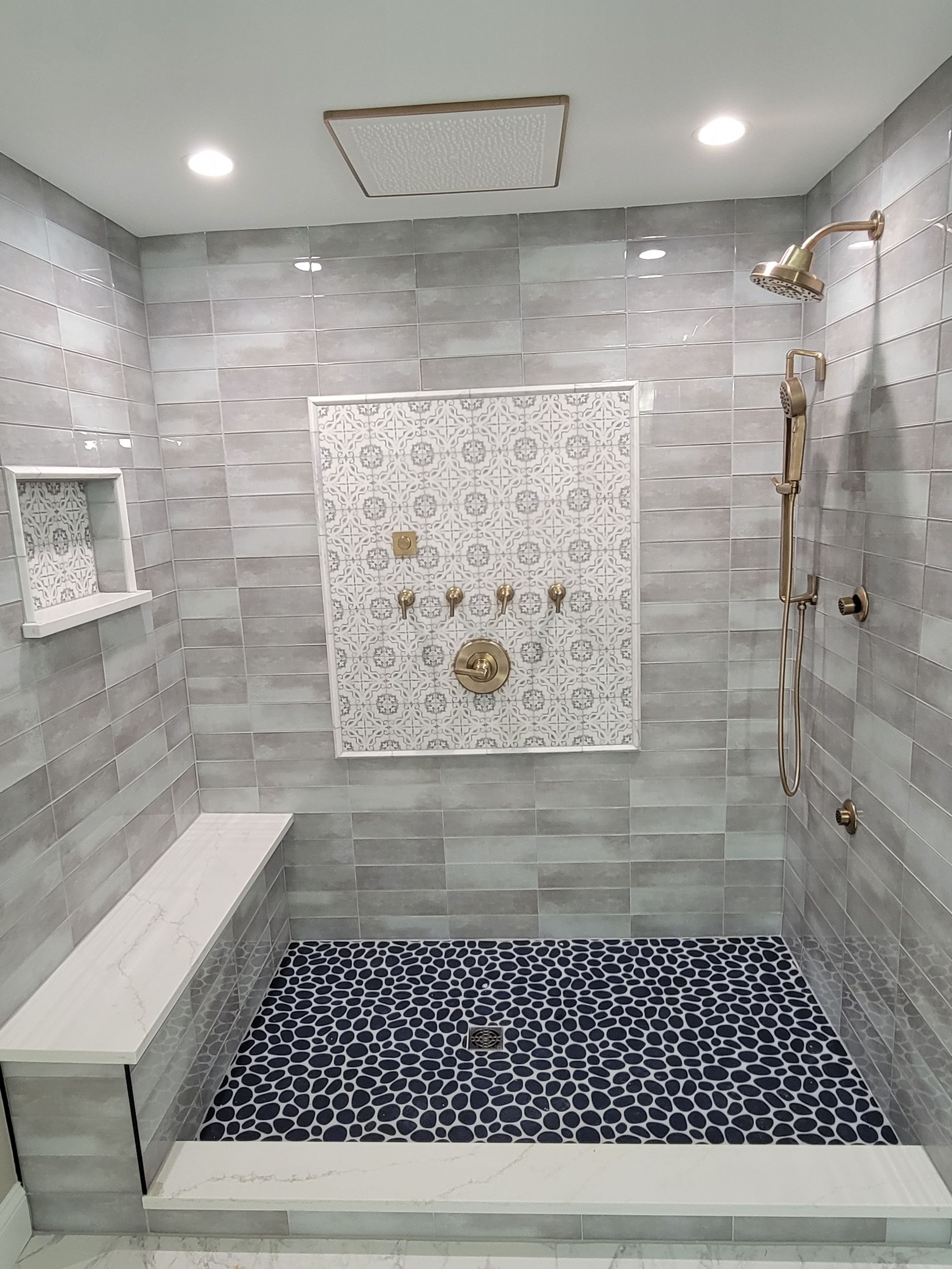 A bathroom with a walk in shower and a bench.