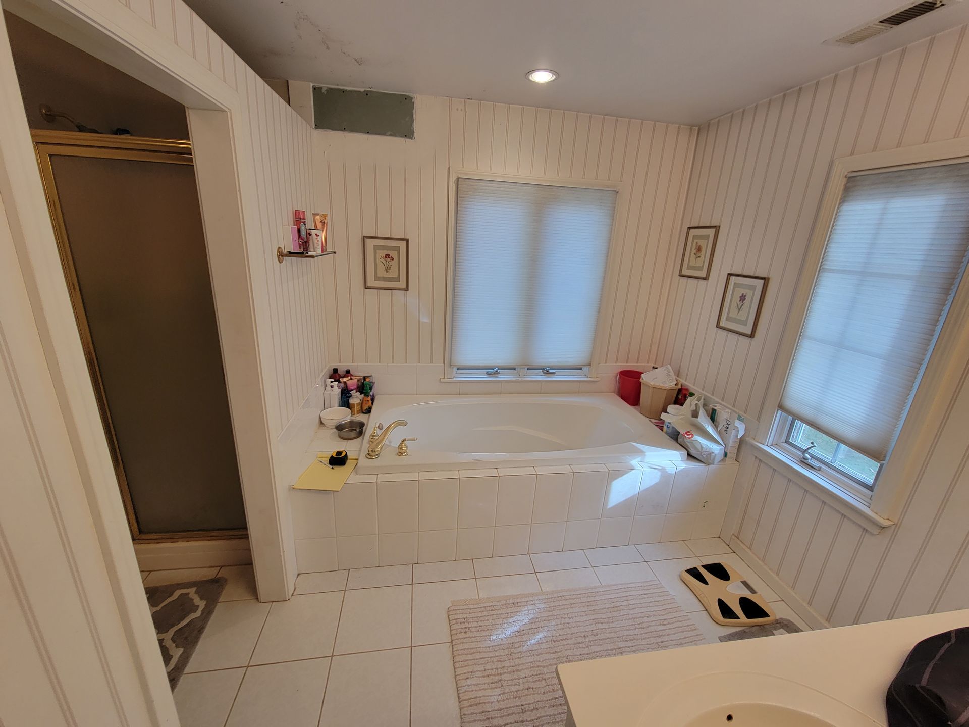 A bathroom with a tub , sink , and shower.