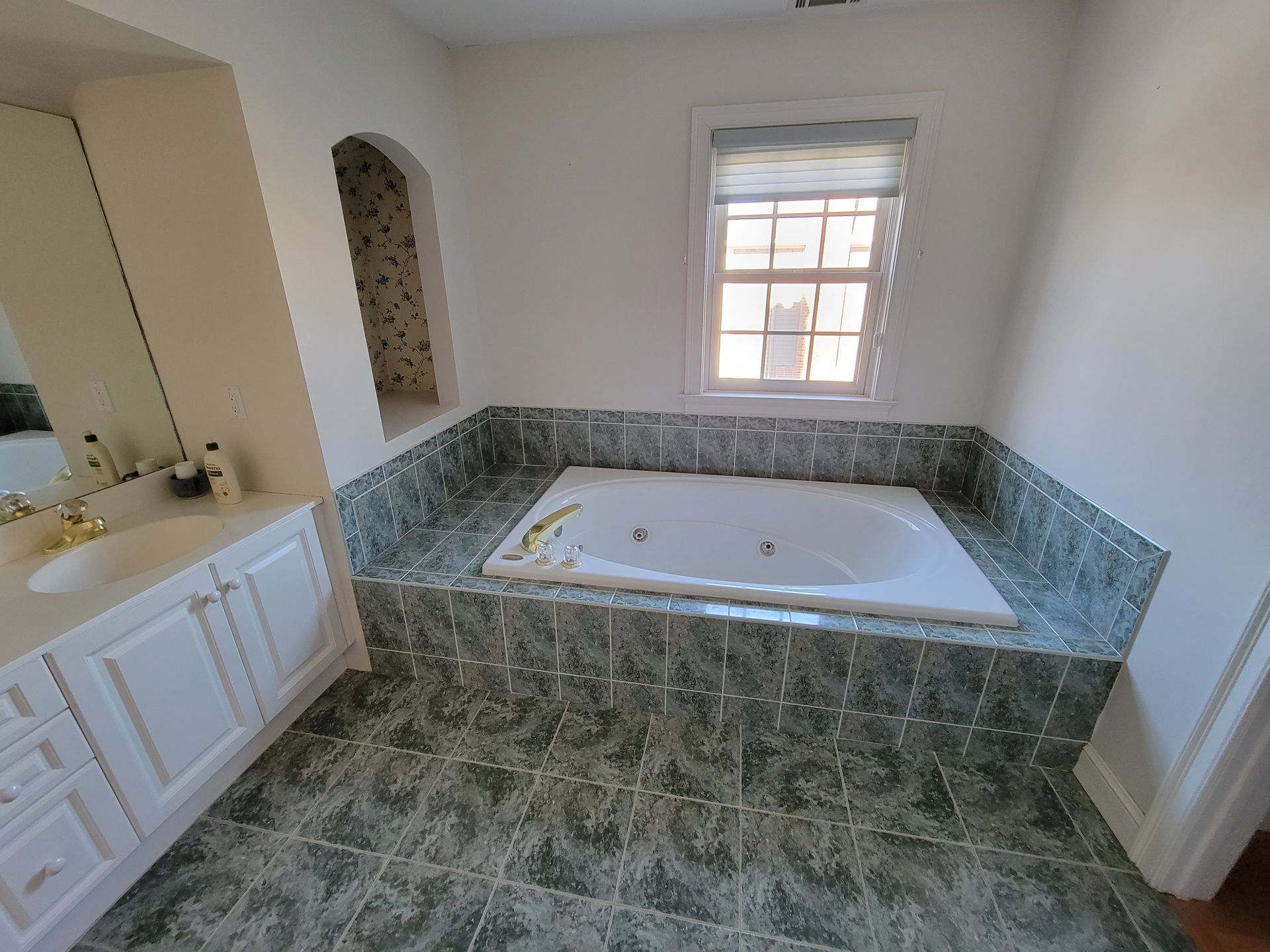 A bathroom with a jacuzzi tub and a sink