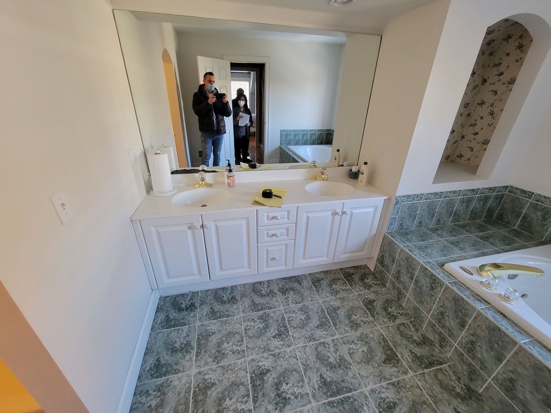 A bathroom with two sinks and a large mirror