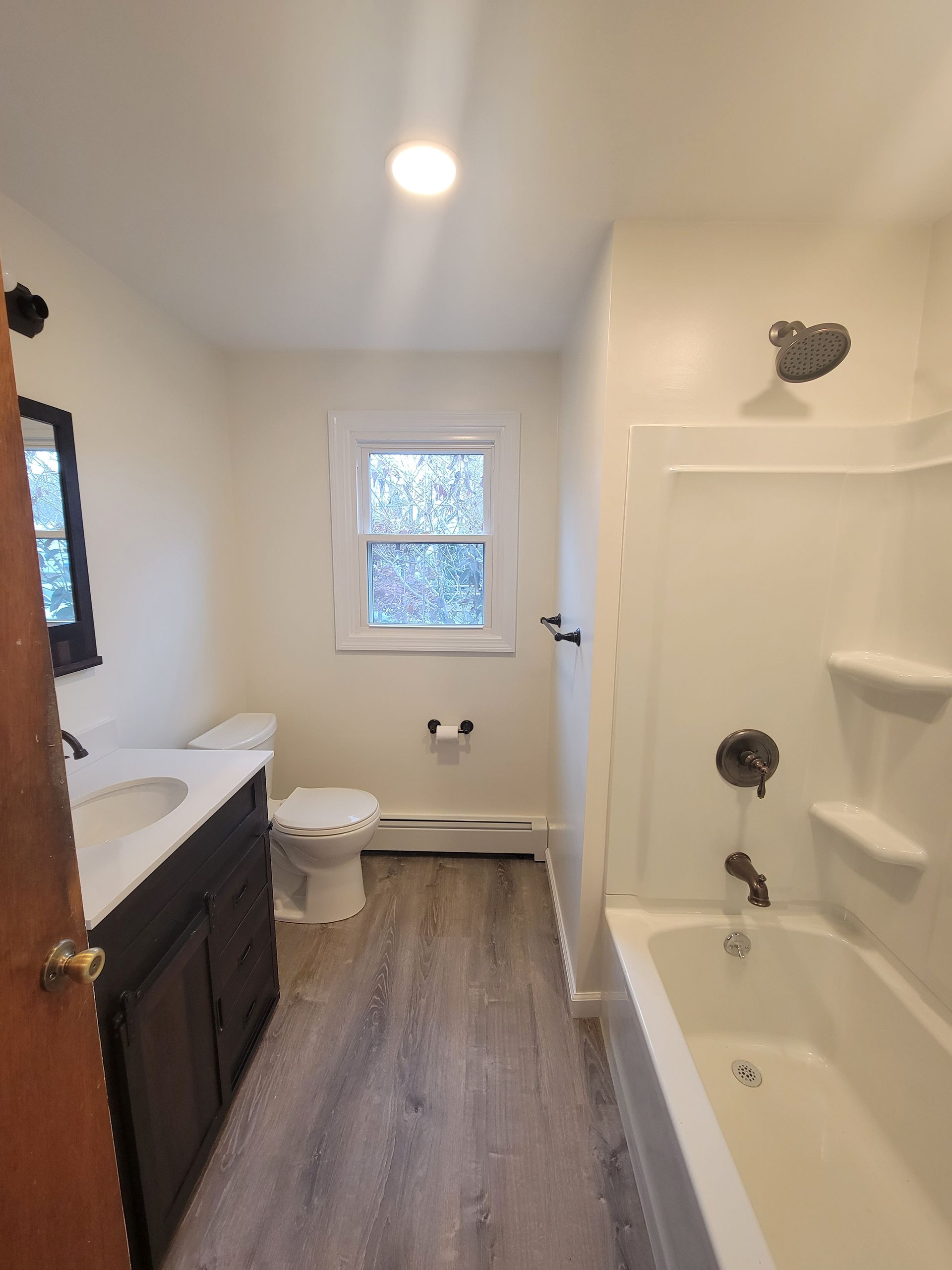 A bathroom with a toilet , sink , and bathtub.