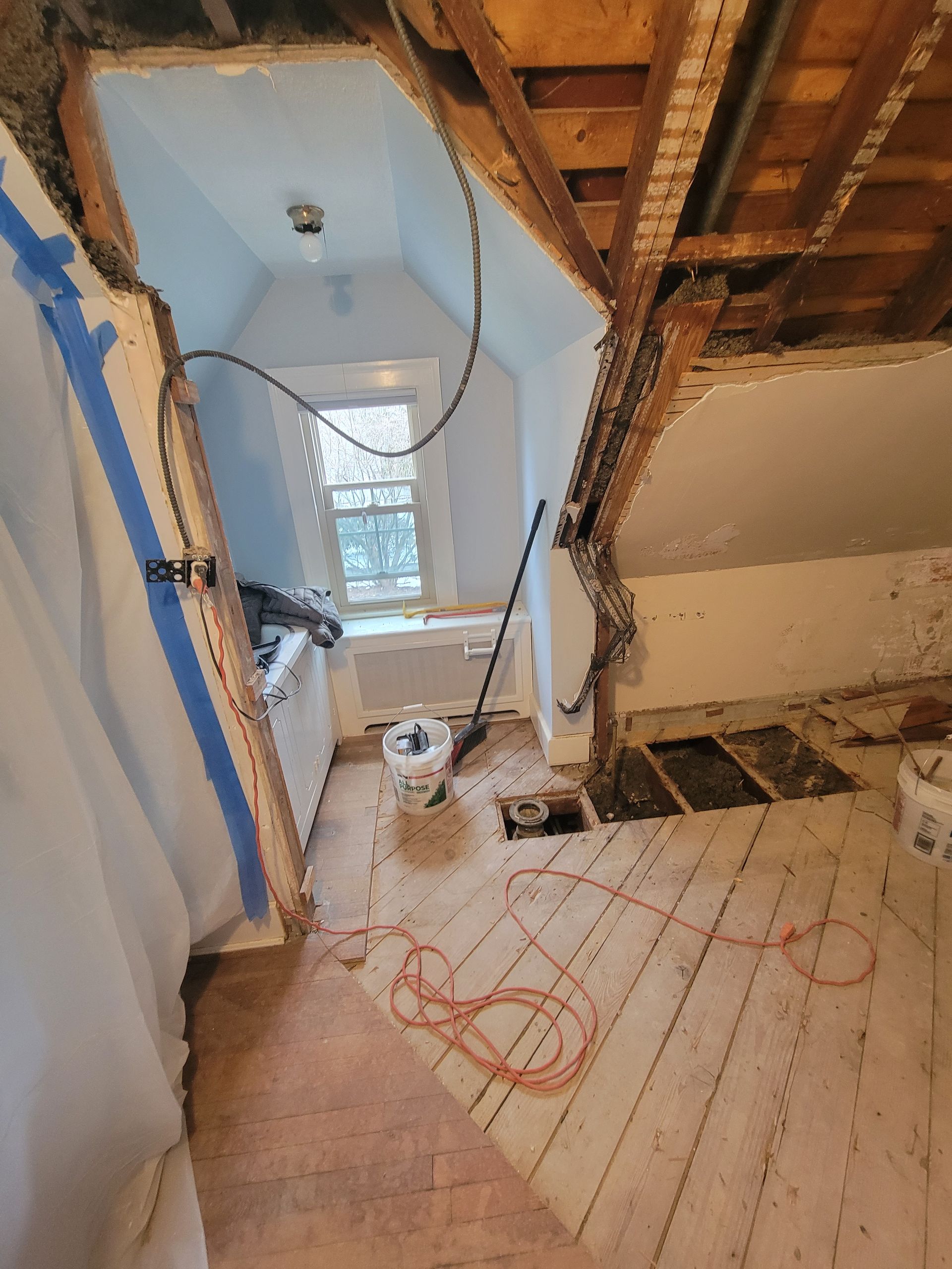A bathroom under construction with a hole in the ceiling.