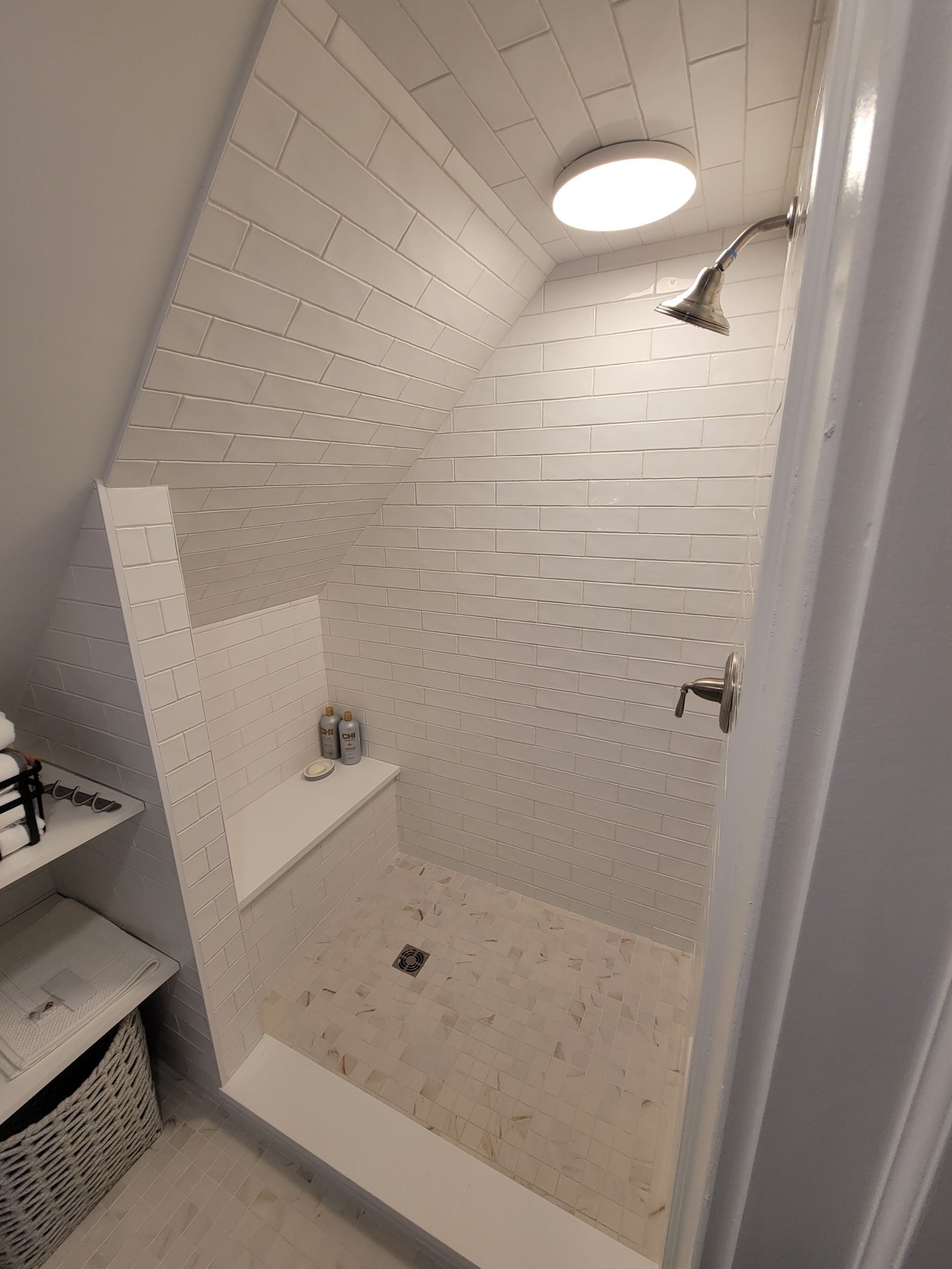 A bathroom with a walk in shower and a light on the ceiling.