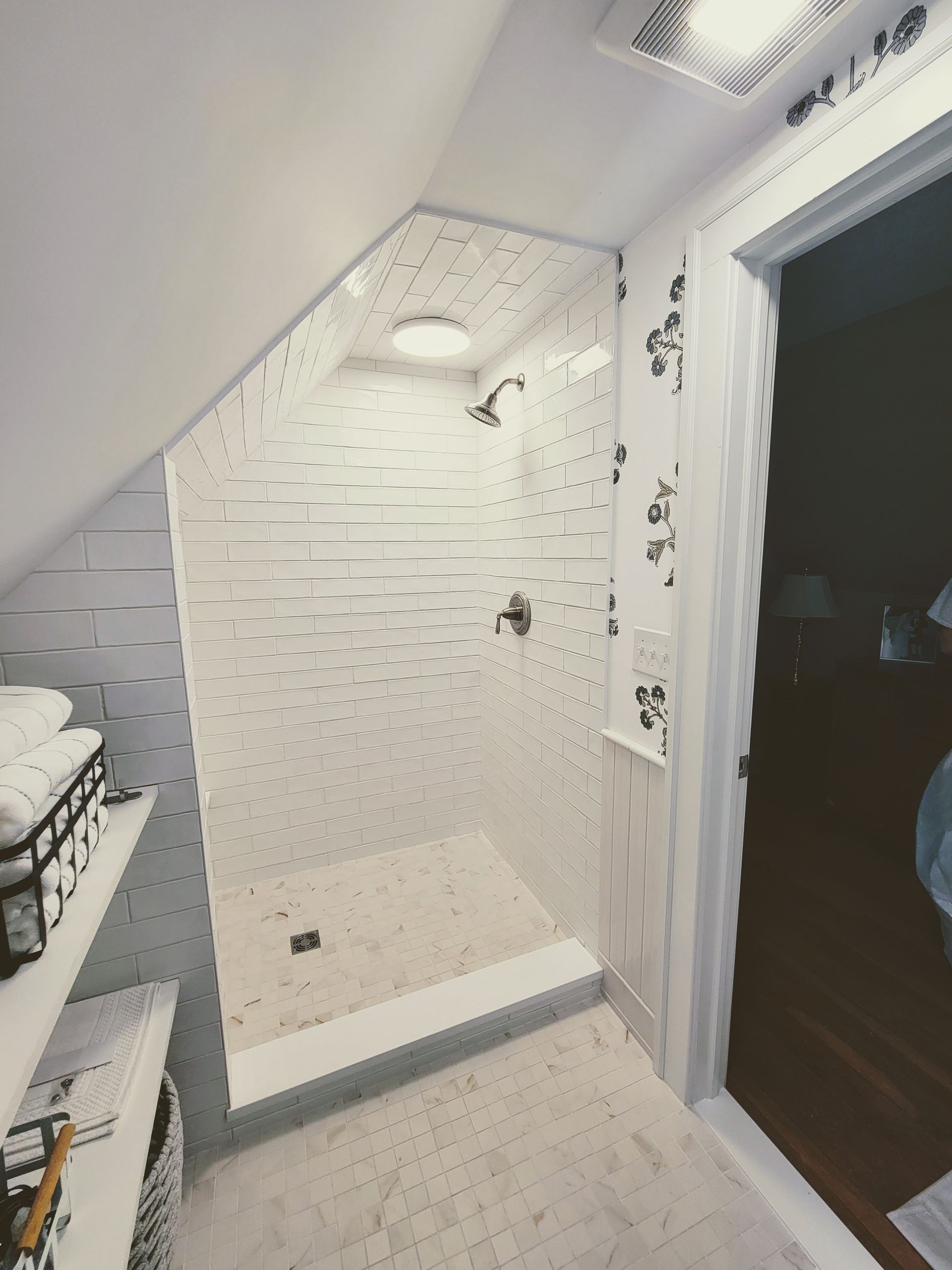 A bathroom with a walk in shower with a glass door
