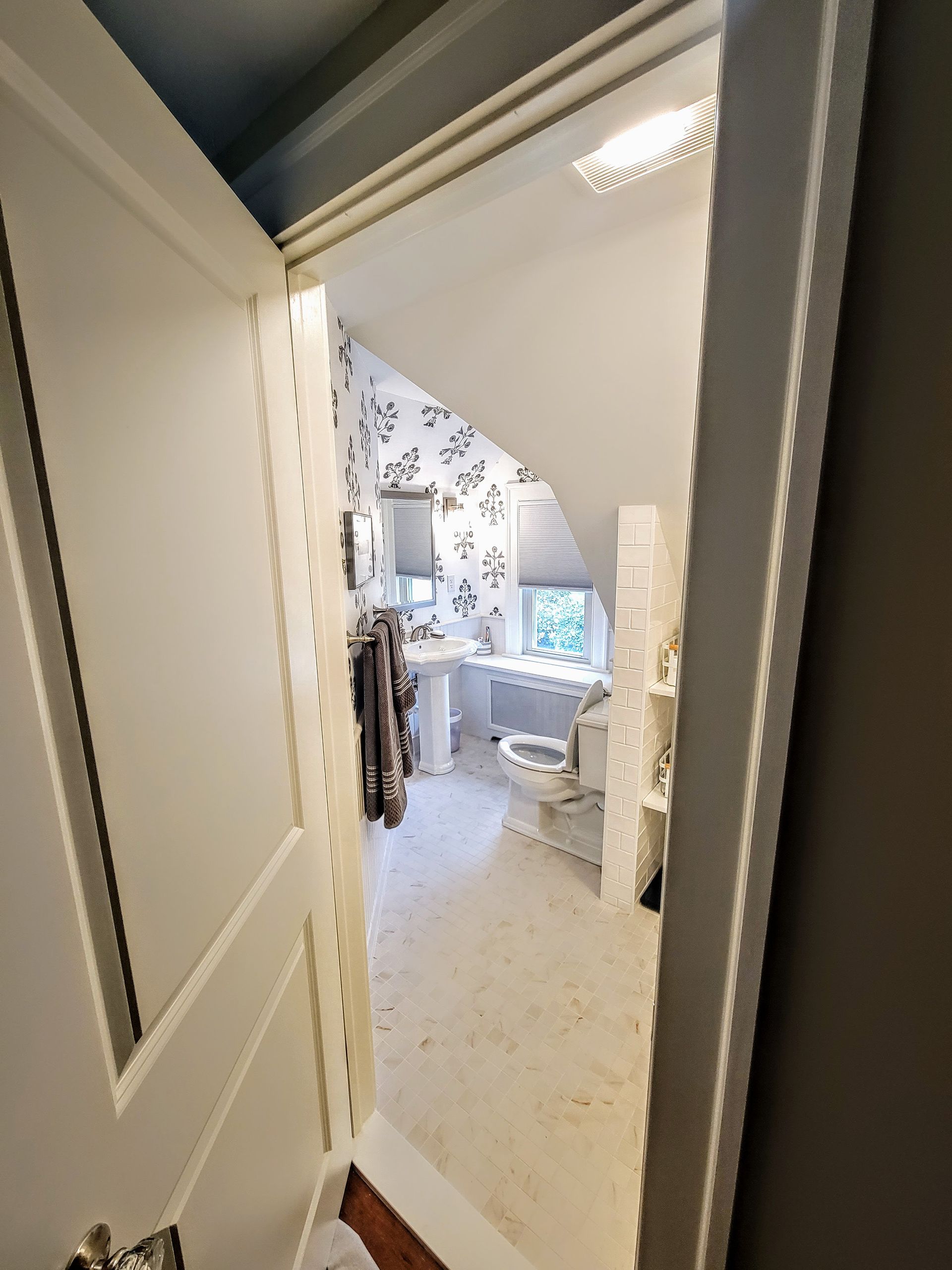 A bathroom with a toilet a sink and a window