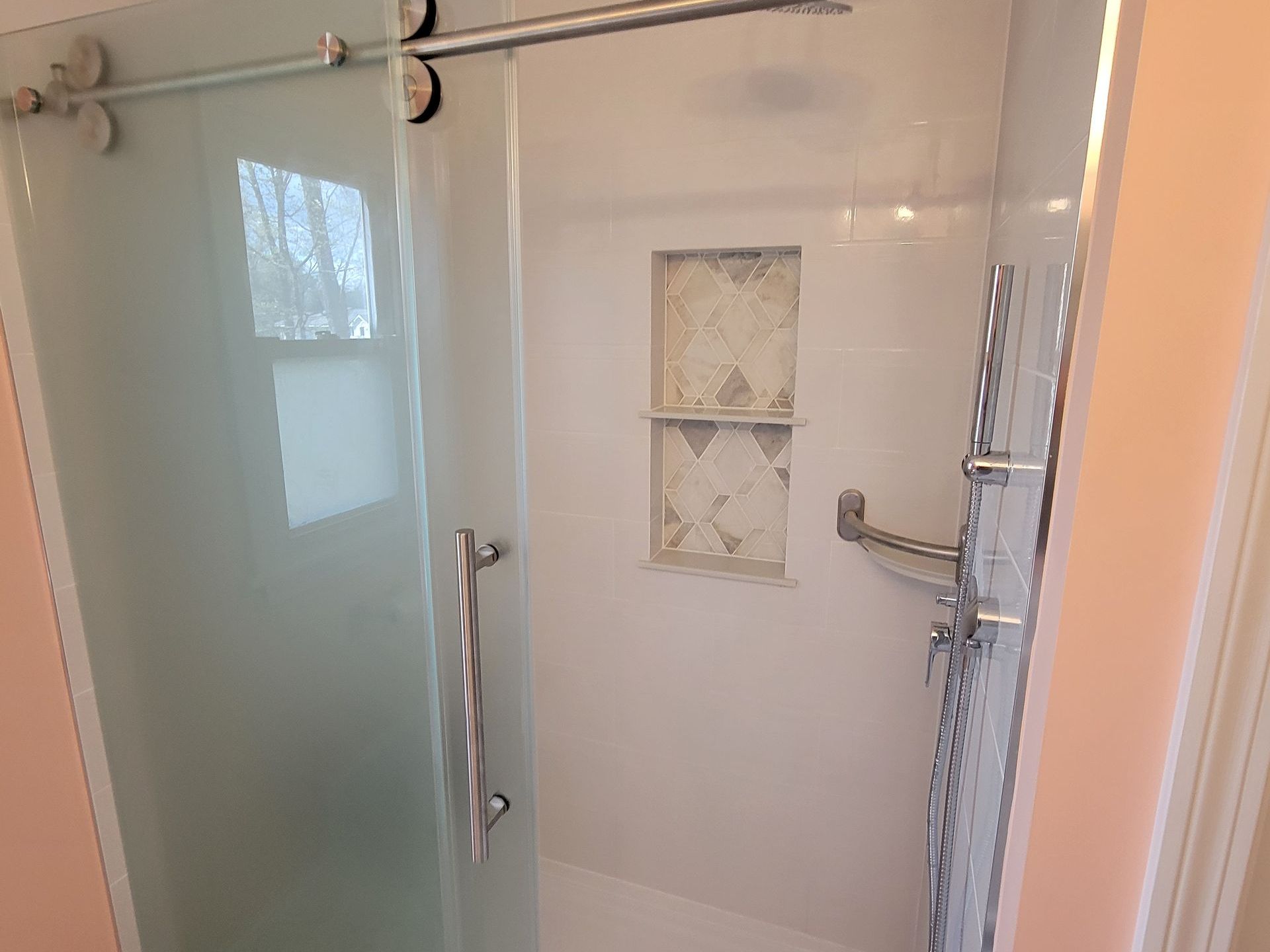 A bathroom with a sliding glass shower door and a bathtub.