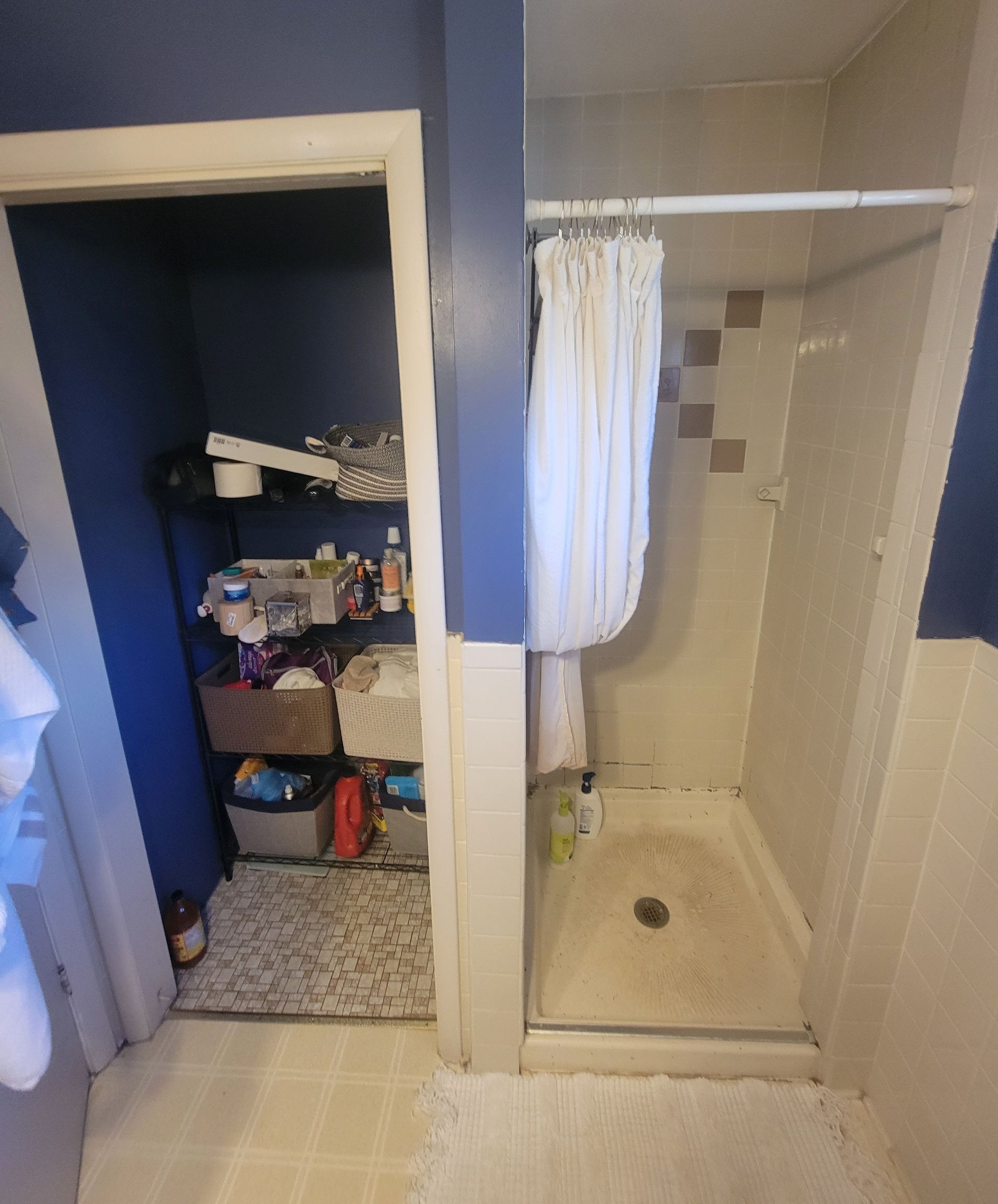A bathroom with a walk in shower and a closet