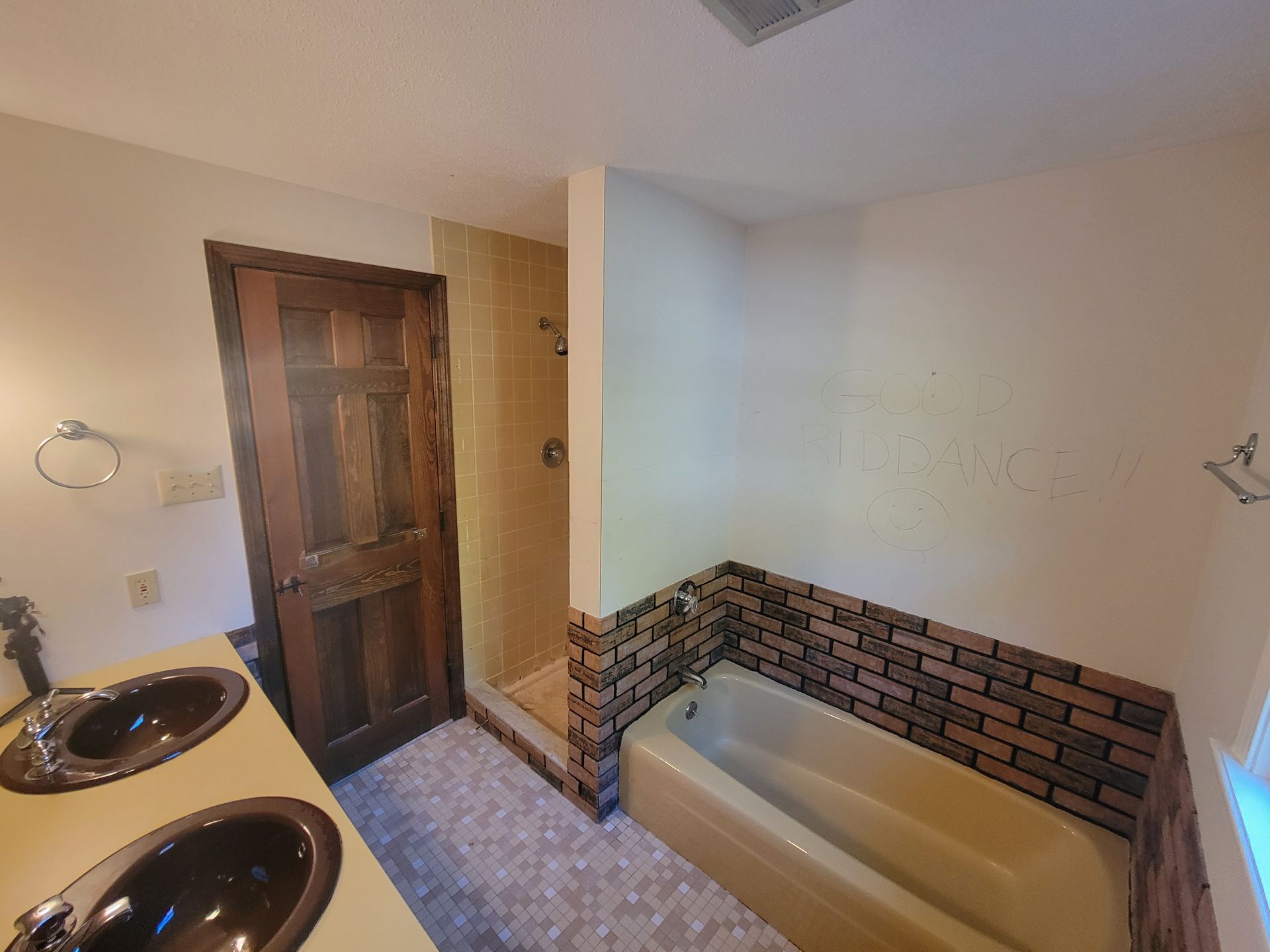 A bathroom with two sinks , a tub and a shower.