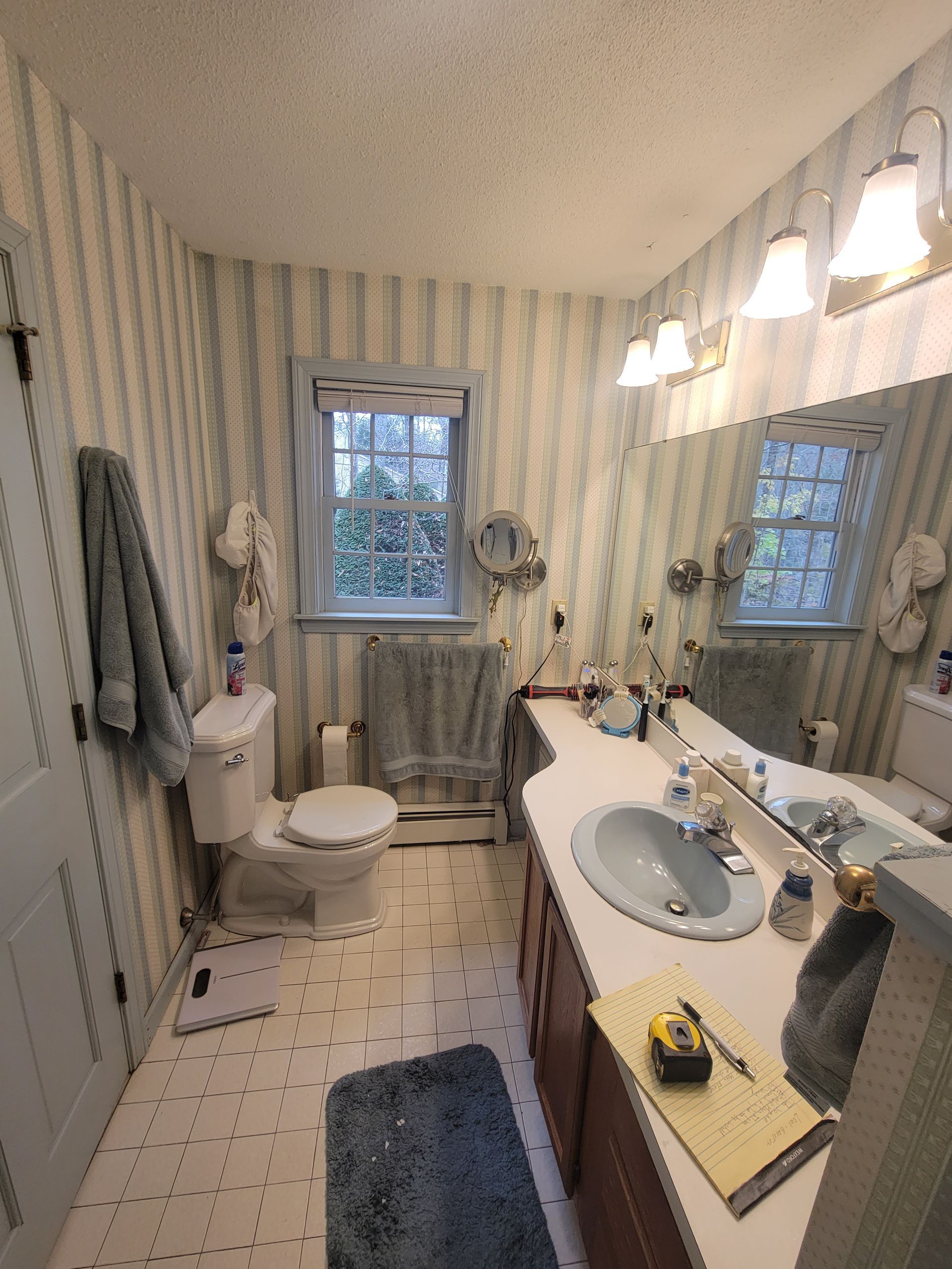 A bathroom with a toilet , sink , and mirror.