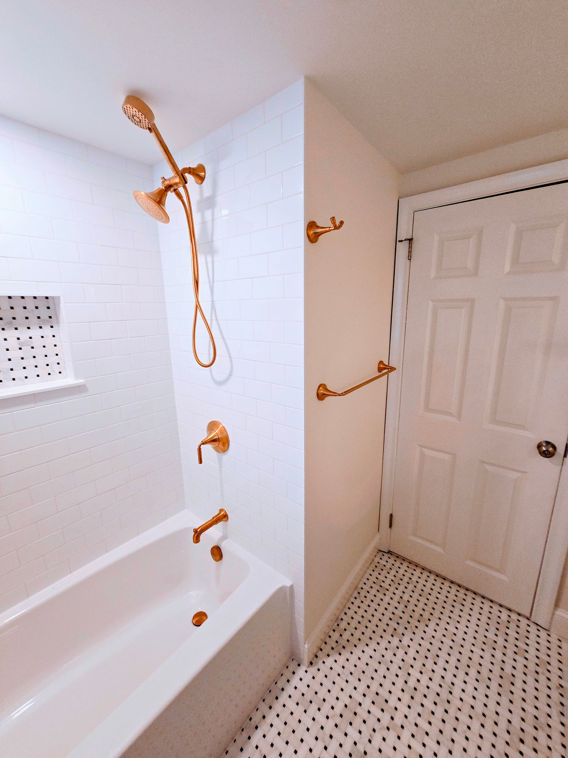 A bathroom with a bathtub and a shower head