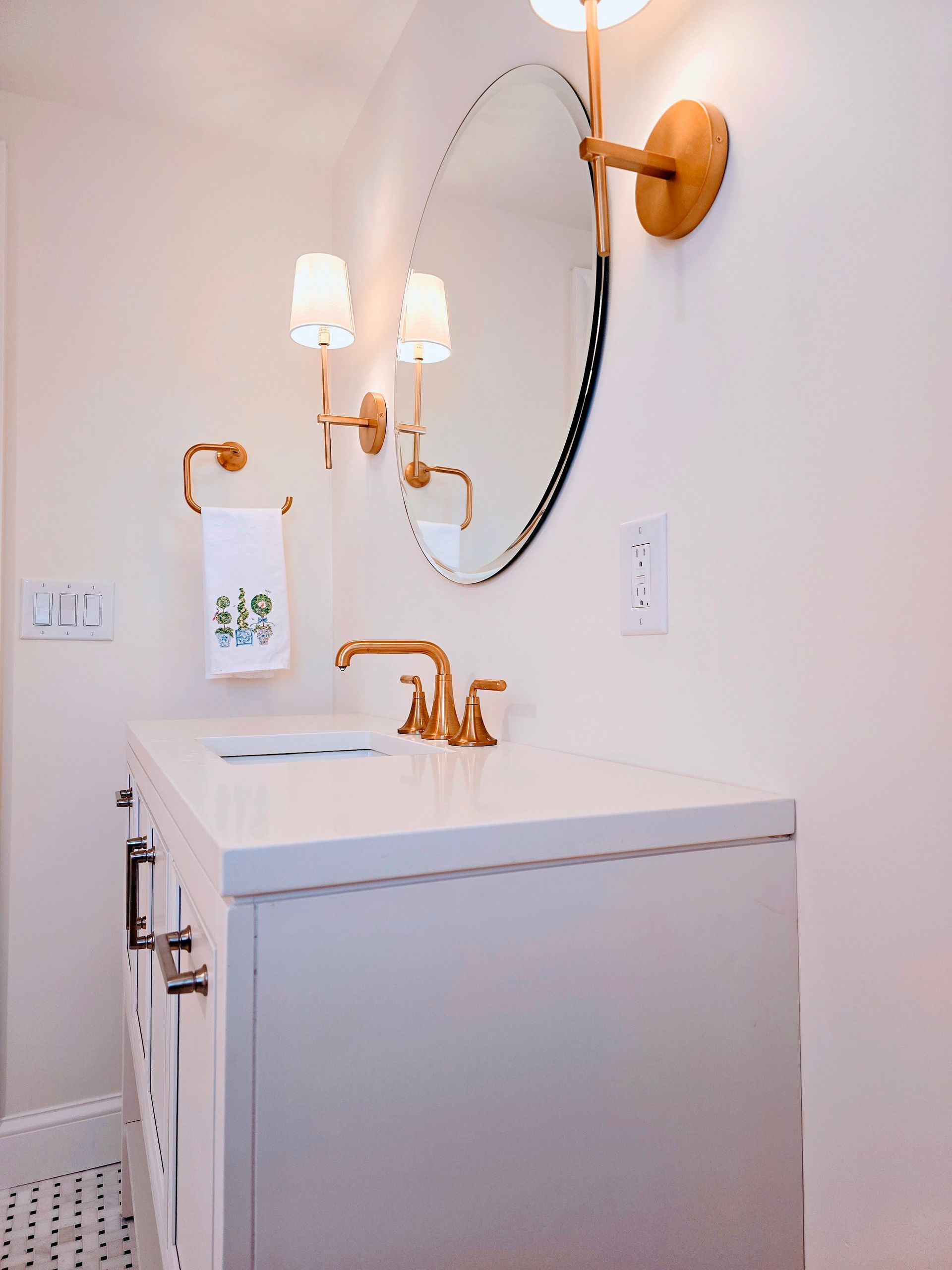 A bathroom with a sink , mirror and lamp