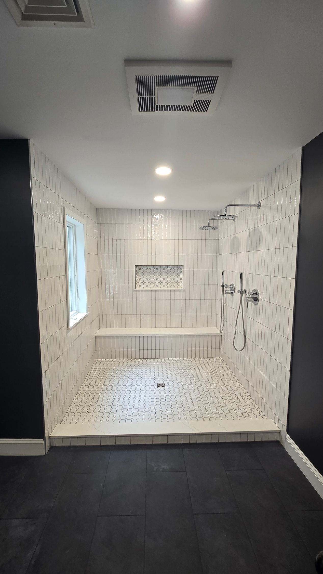 A bathroom with a walk in shower and a window.