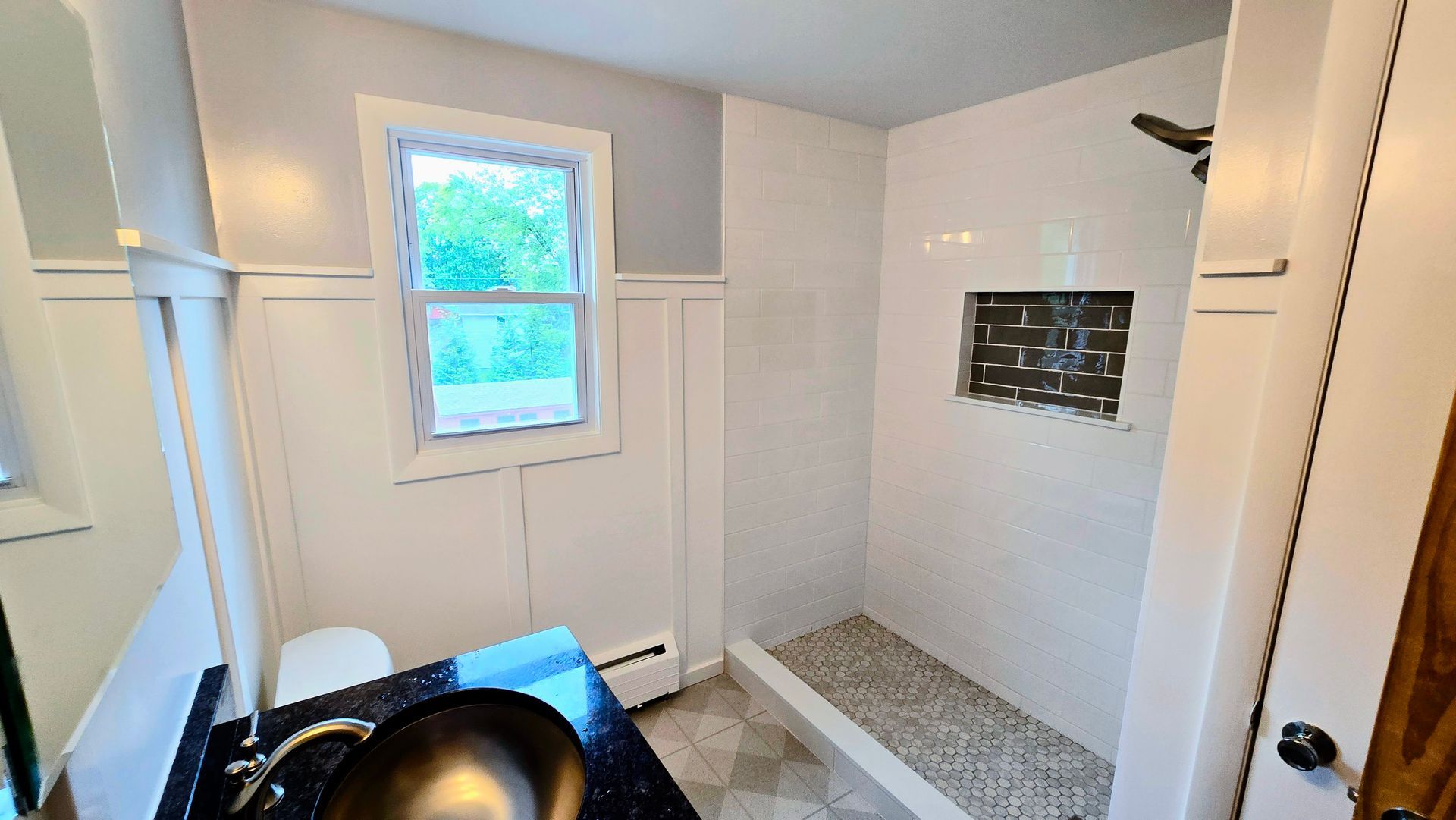 A bathroom with a sink and a walk in shower.