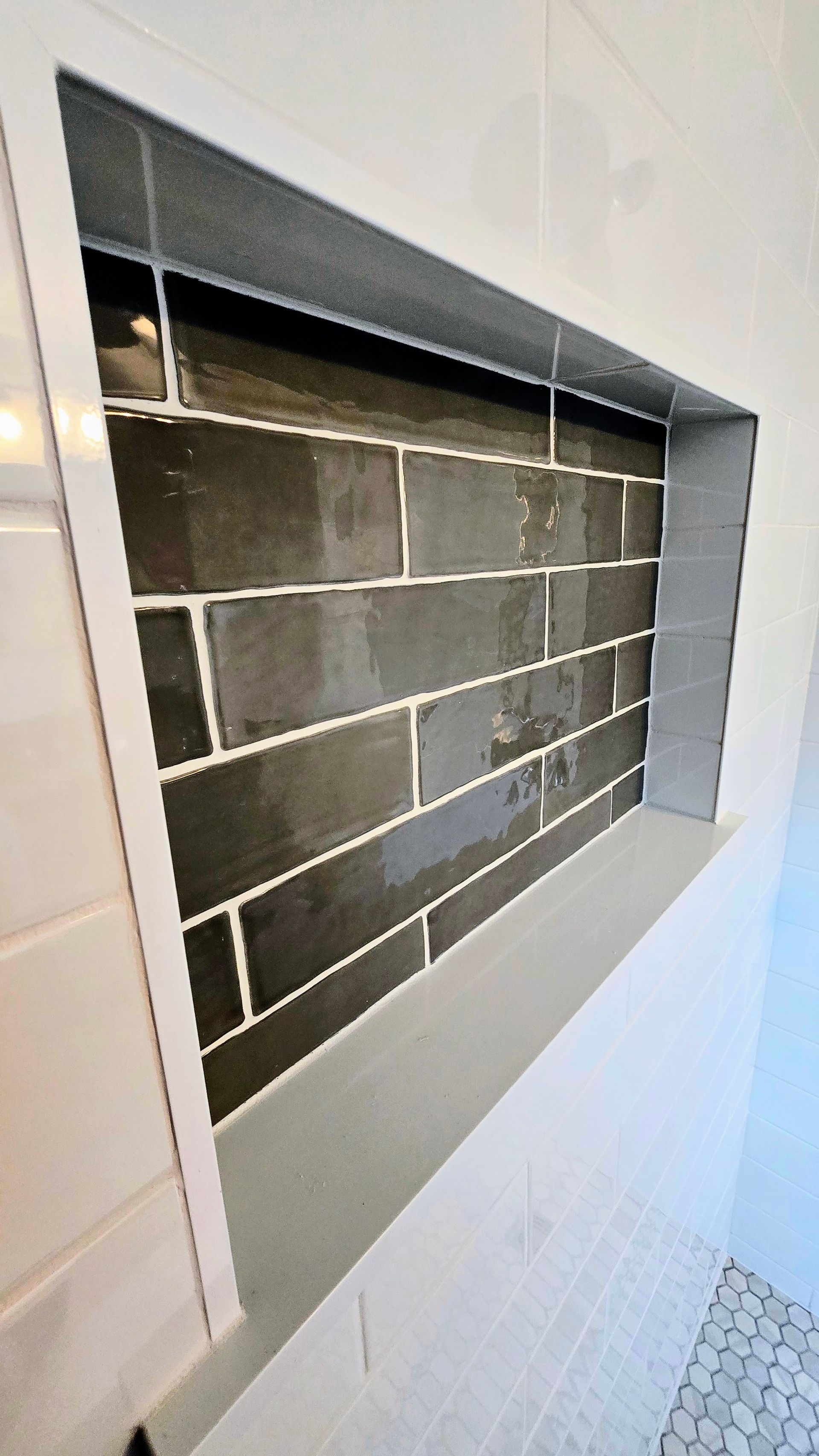 A bathroom with black and white tiles and a window.