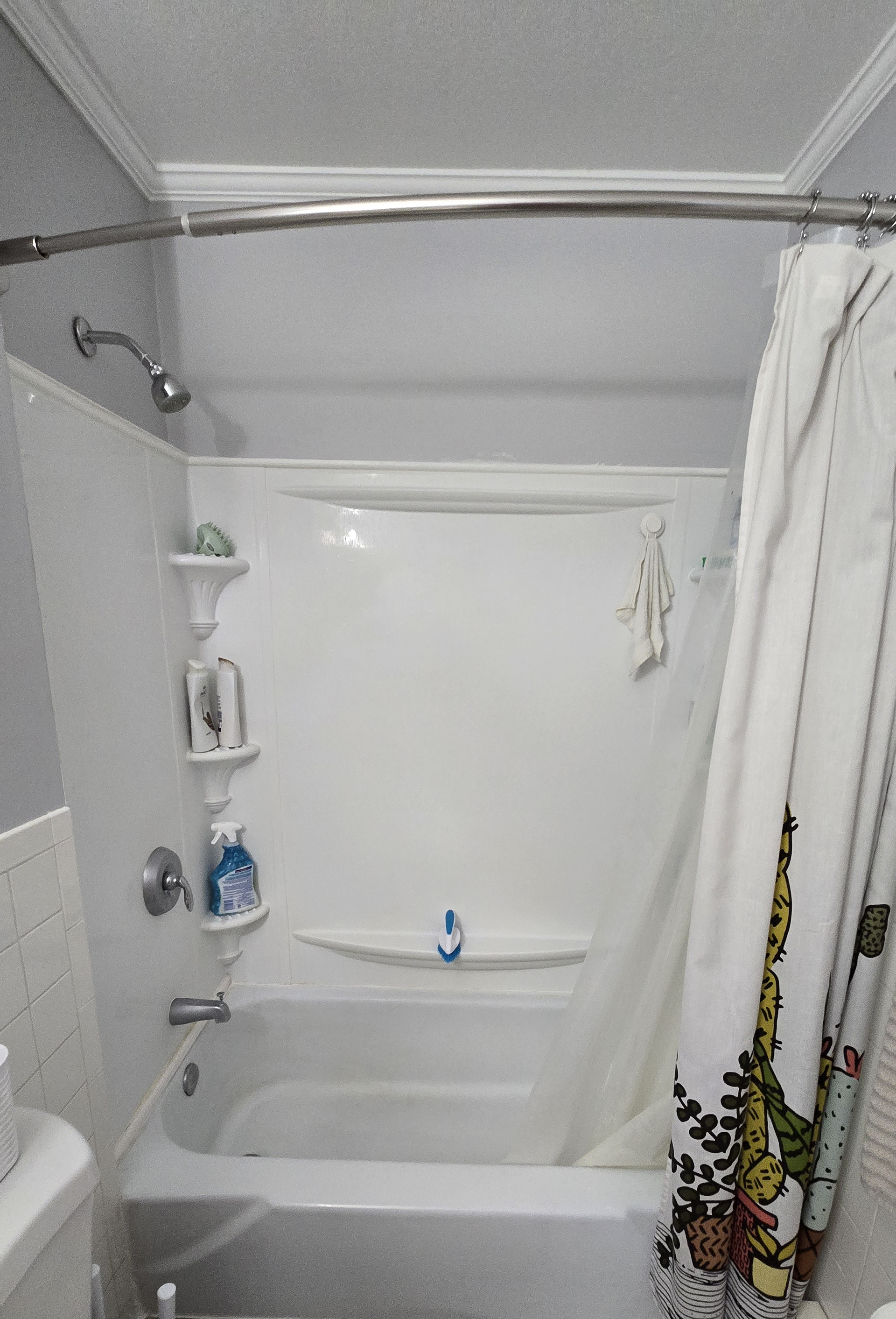 A bathroom with a bathtub , shower and toilet.