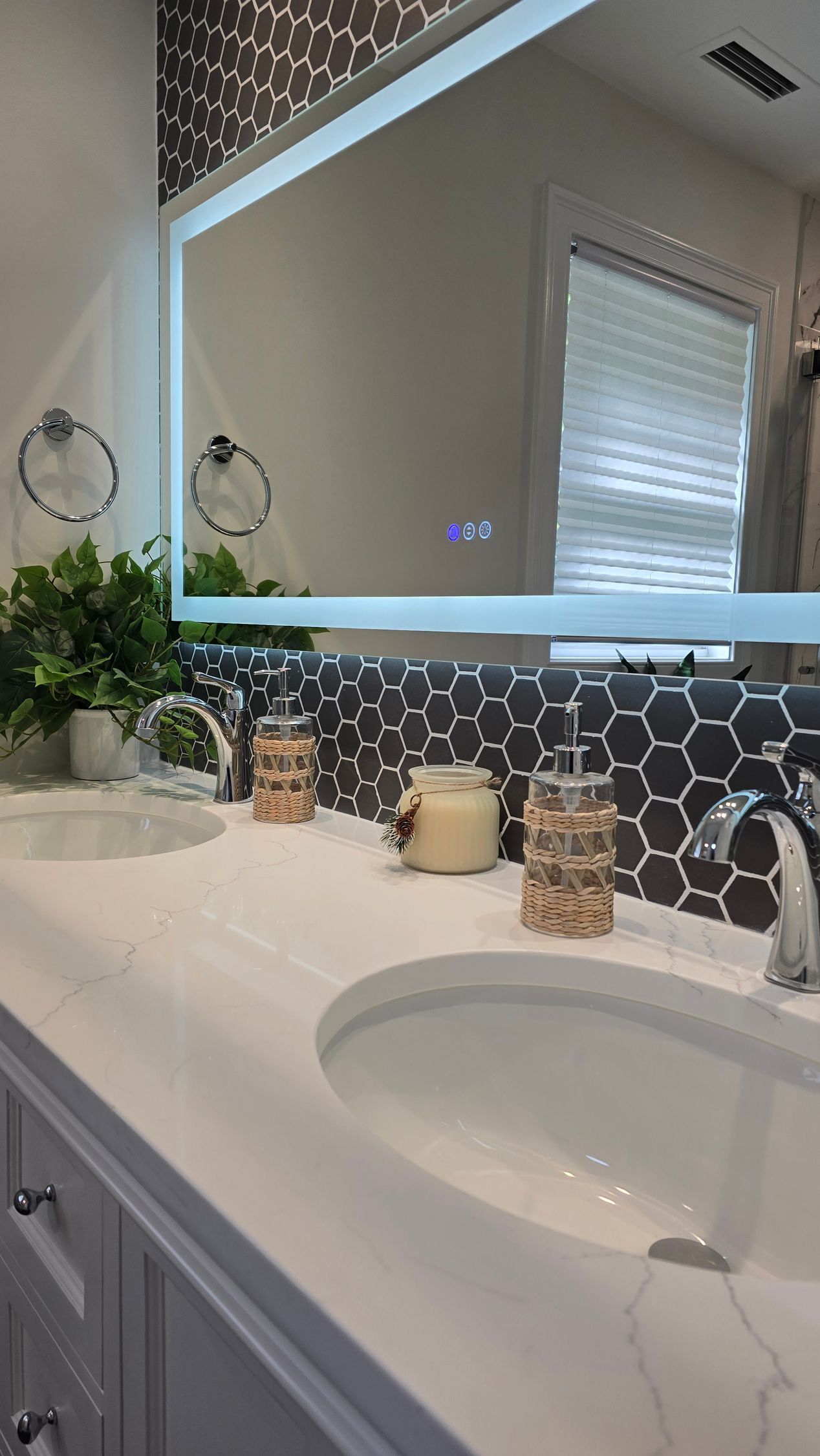 A bathroom with two sinks and a large mirror.