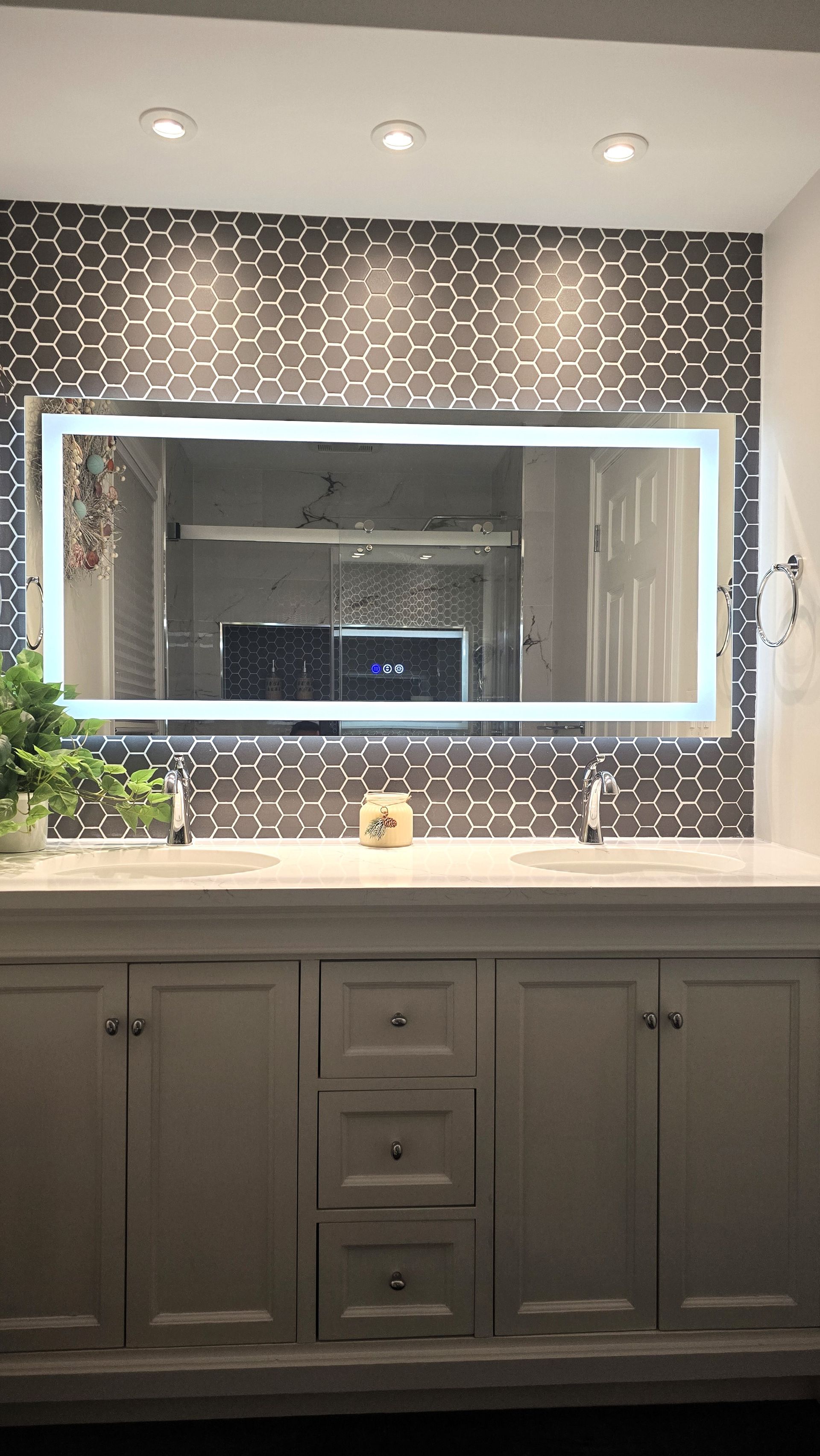 A bathroom with a large mirror and two sinks.