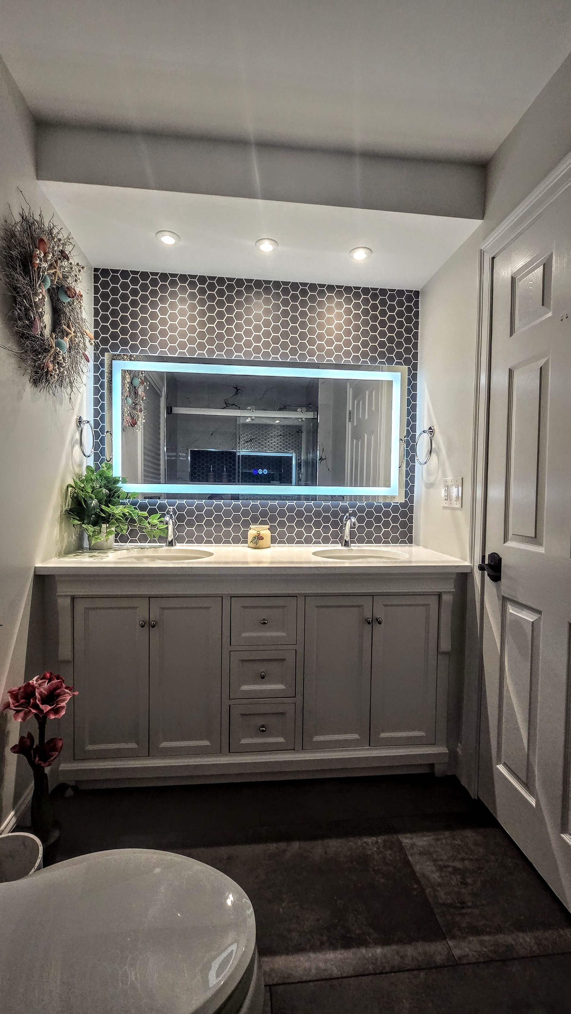 A bathroom with a toilet , sink and mirror.