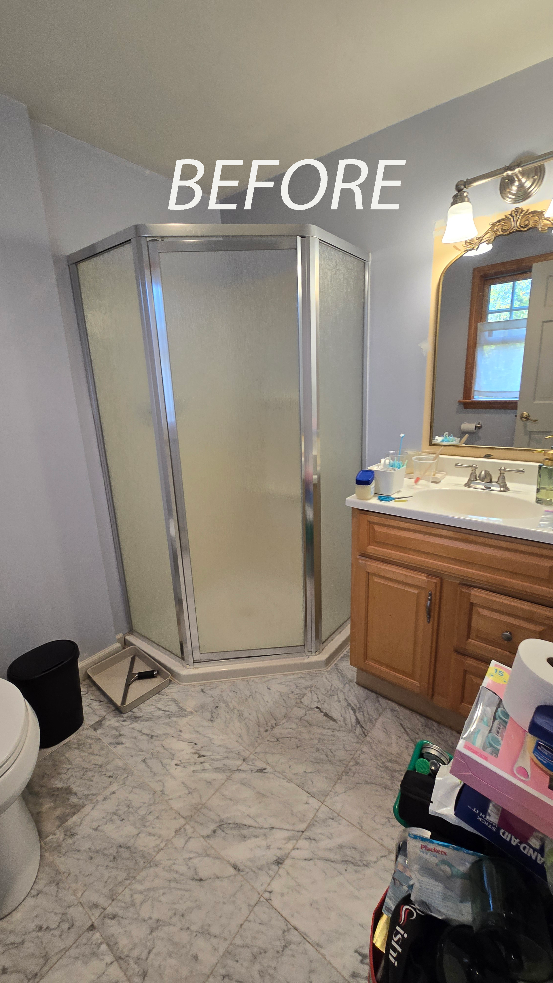 Bathroom with a triangular shower, vanity, toilet, and marble-look floor; labeled 