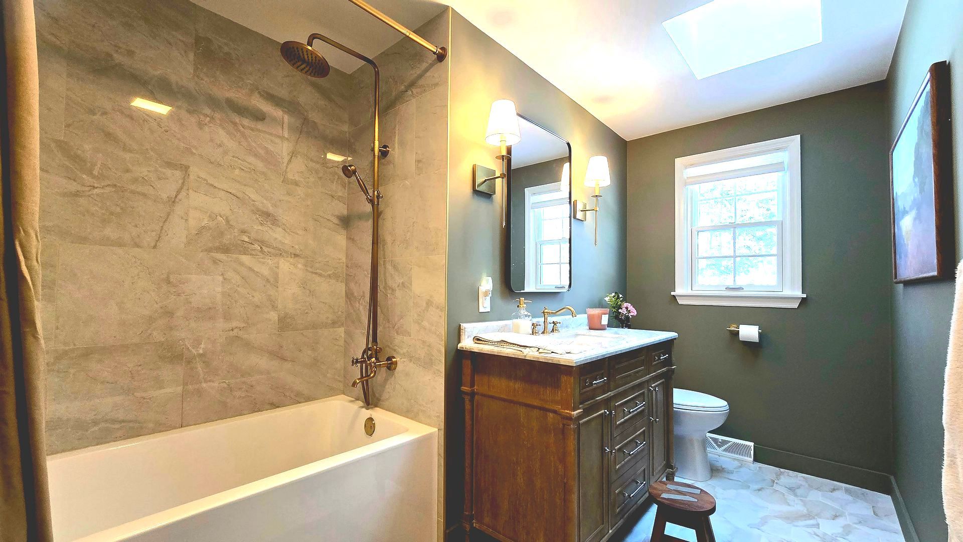 A bathroom with a tub , sink , toilet and shower.