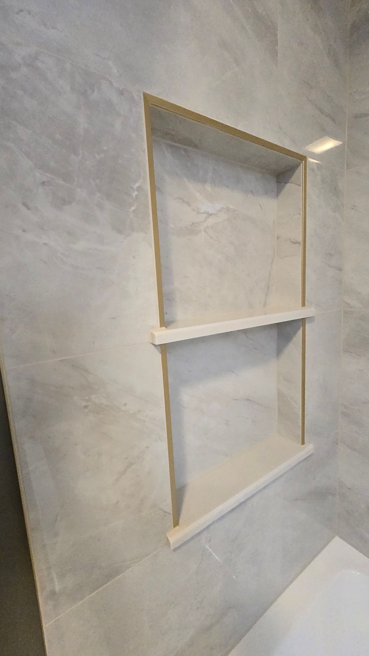 A bathroom sink with a brass faucet and marble counter top
