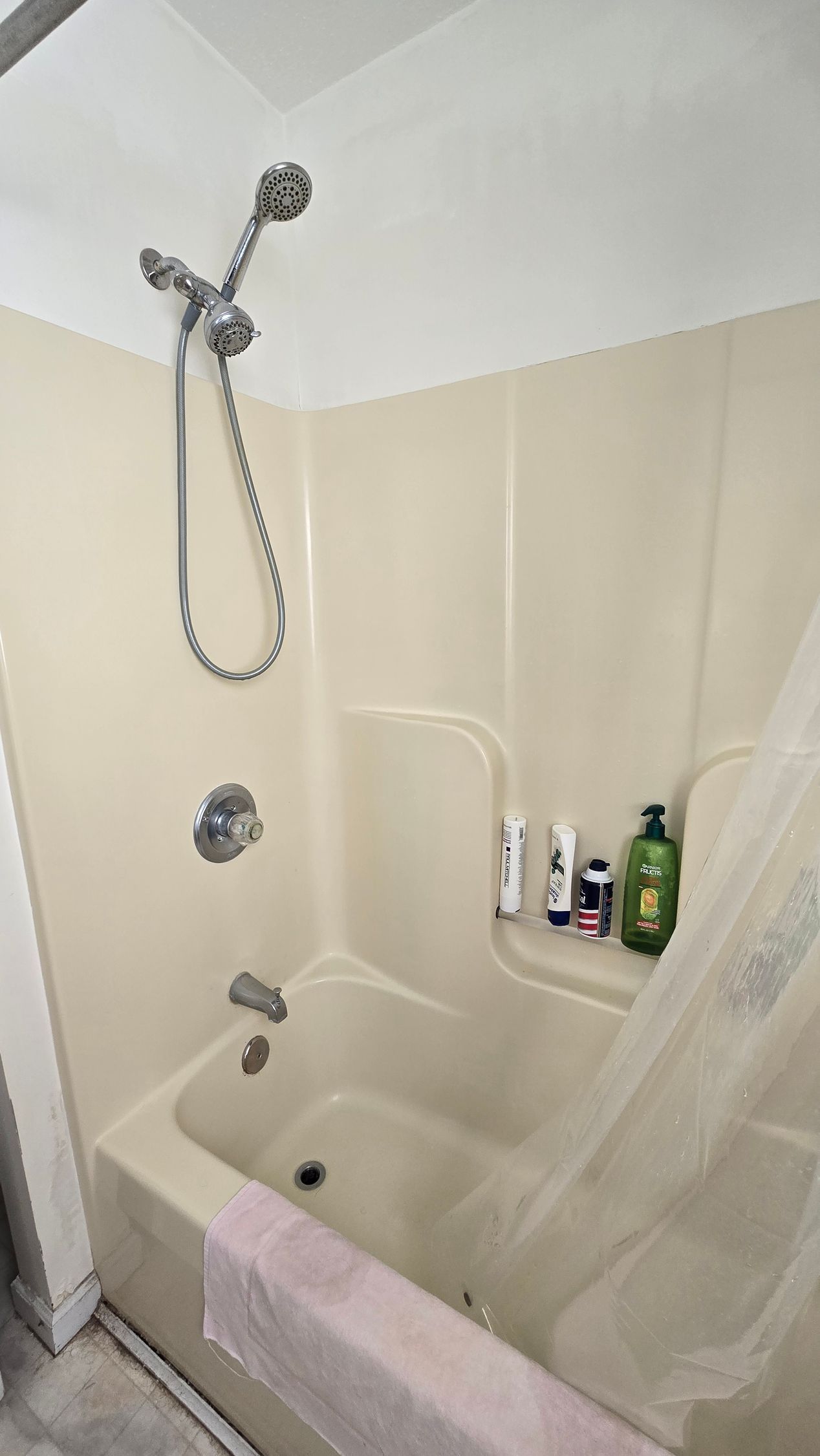 A bathroom under construction with a walk in shower and a window.