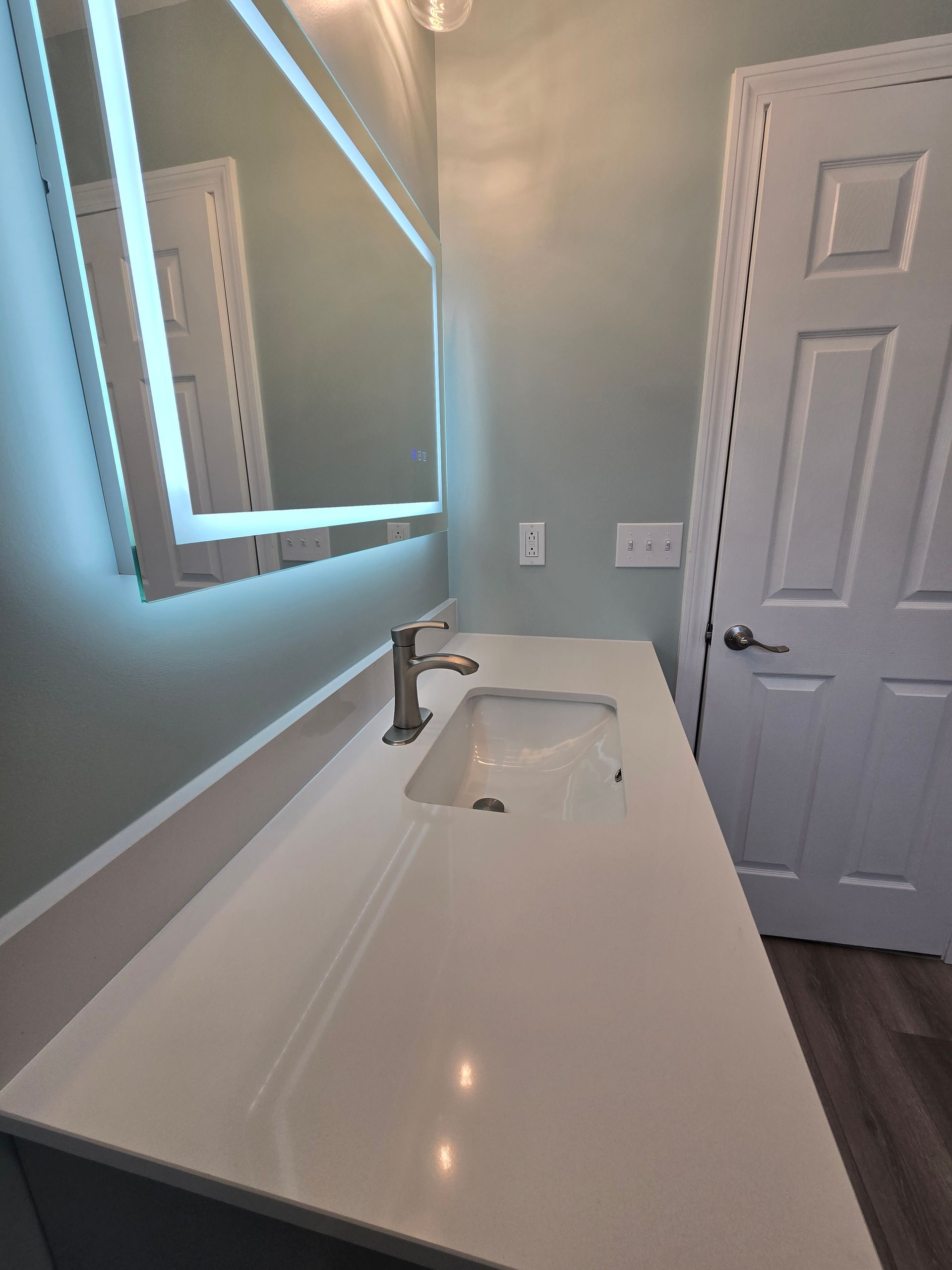 A bathroom sink with a brass faucet and marble counter top