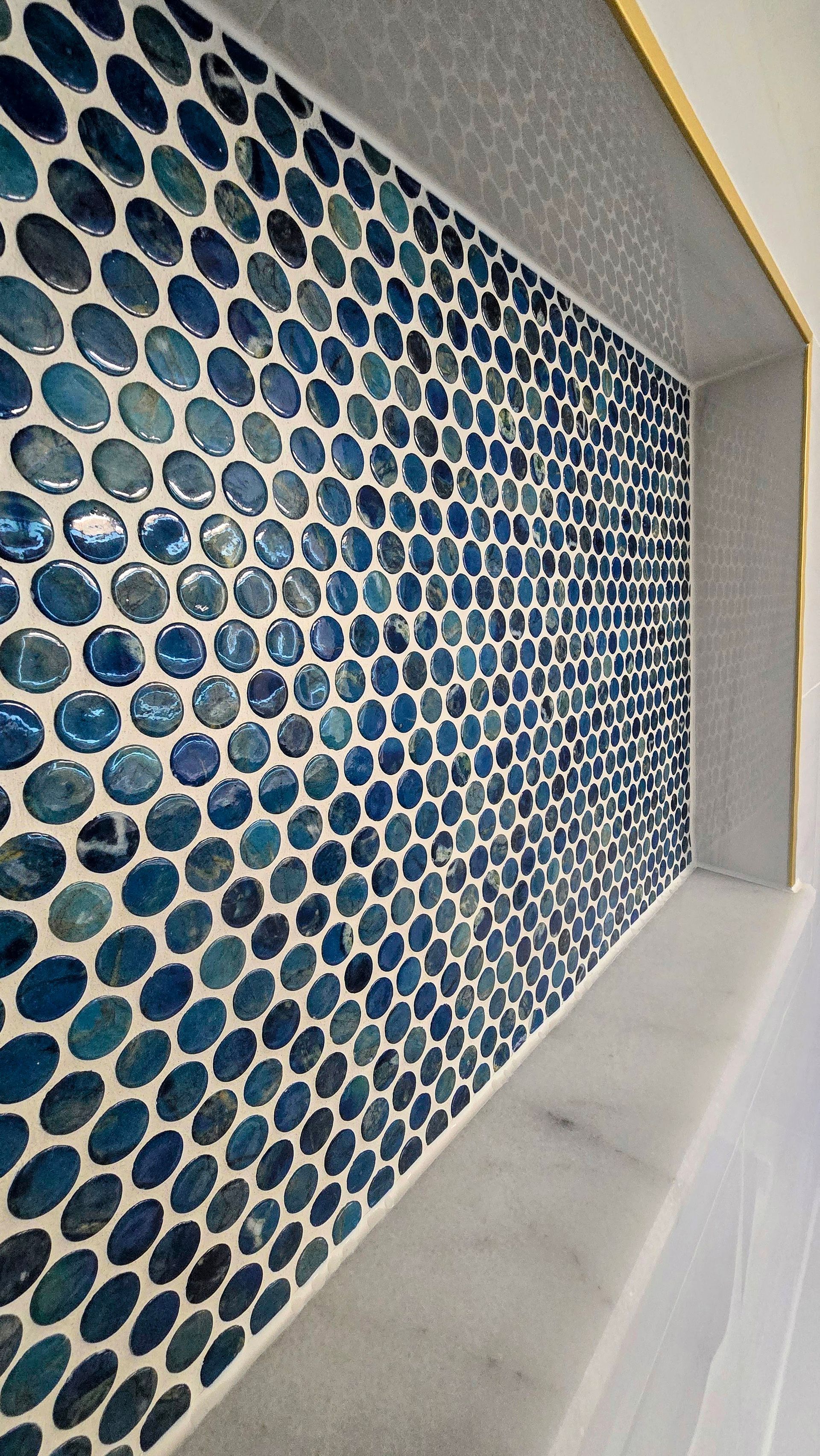 A close up of a blue and white tile wall in a bathroom.