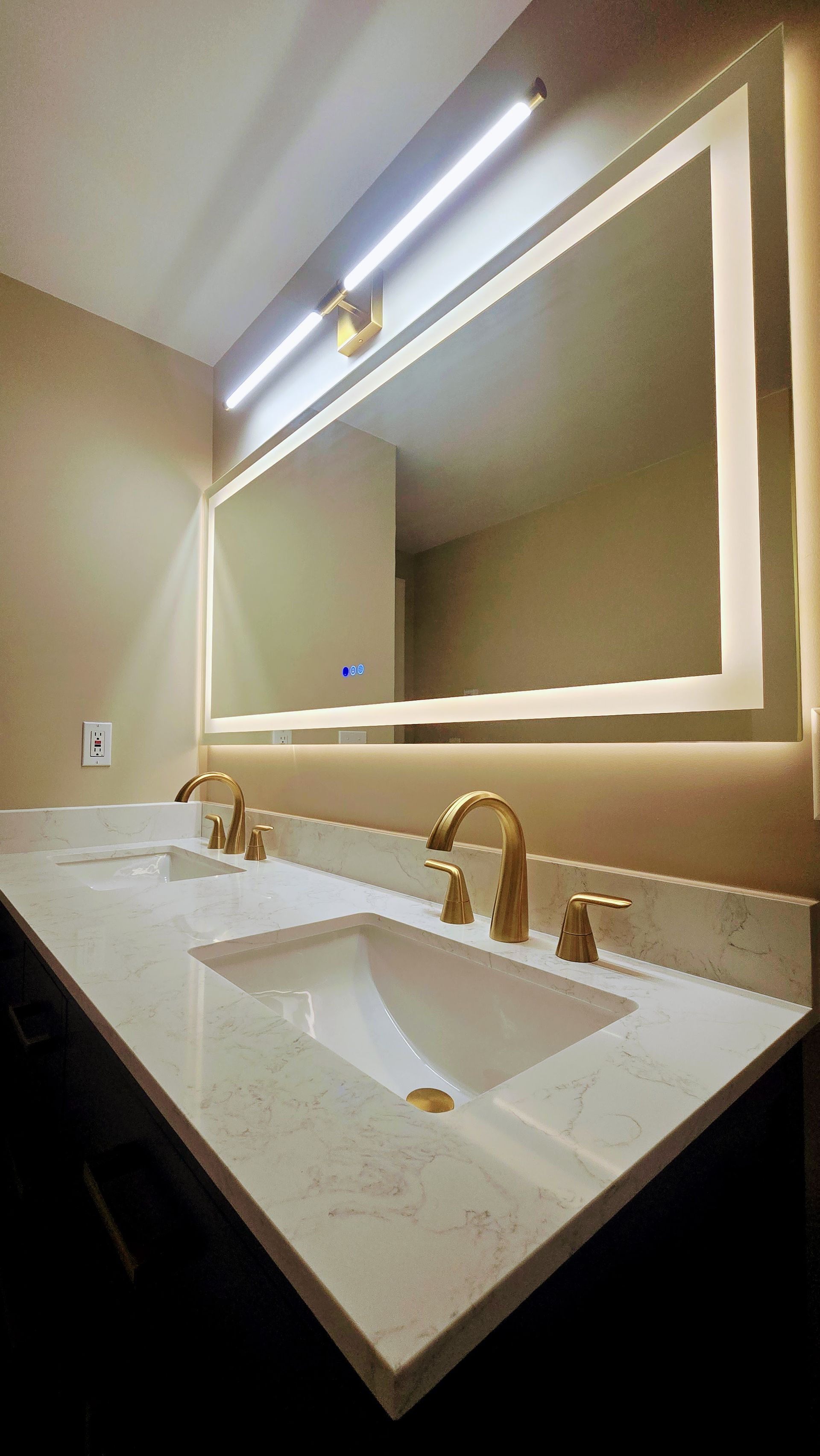 A bathroom with two sinks and a large mirror.